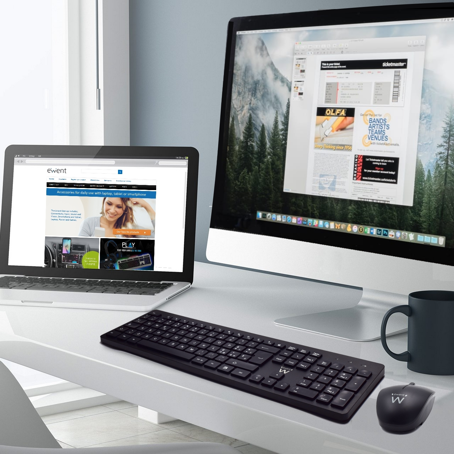 Konfiguracja biurka z laptopami, klawiaturą, myszą i kubkiem. Widok gór na monitorze.