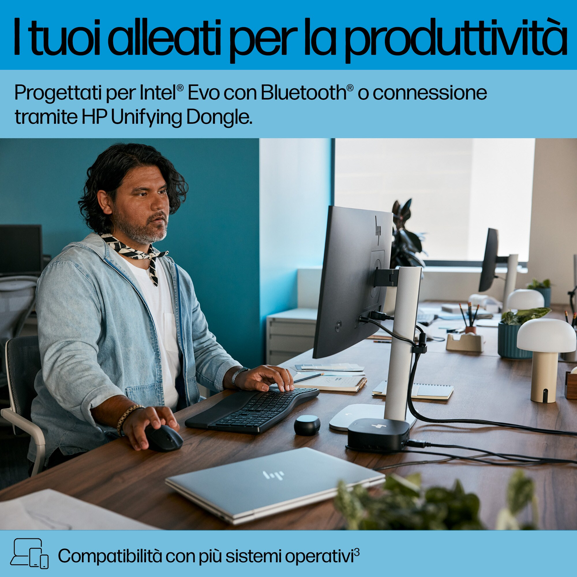 Uomo che lavora alla scrivania con monitor. Tastiera e mouse. Laptop sulla scrivania. Testo in alto.