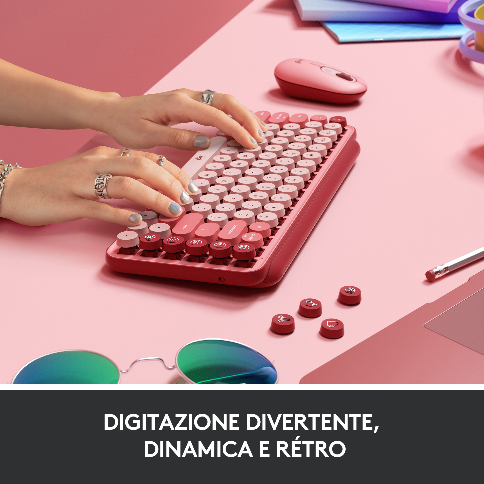Una persona che digita su una tastiera rossa con tasti rotondi. Un mouse rosa è accanto.