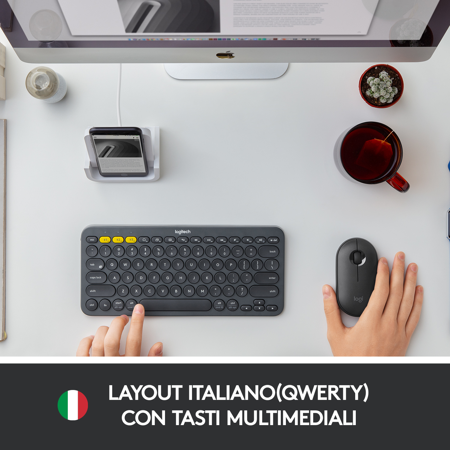 Tastiera e mouse grigi, mani in uso, testo: Layout Italiano(QWERTY), bandiera italiana.