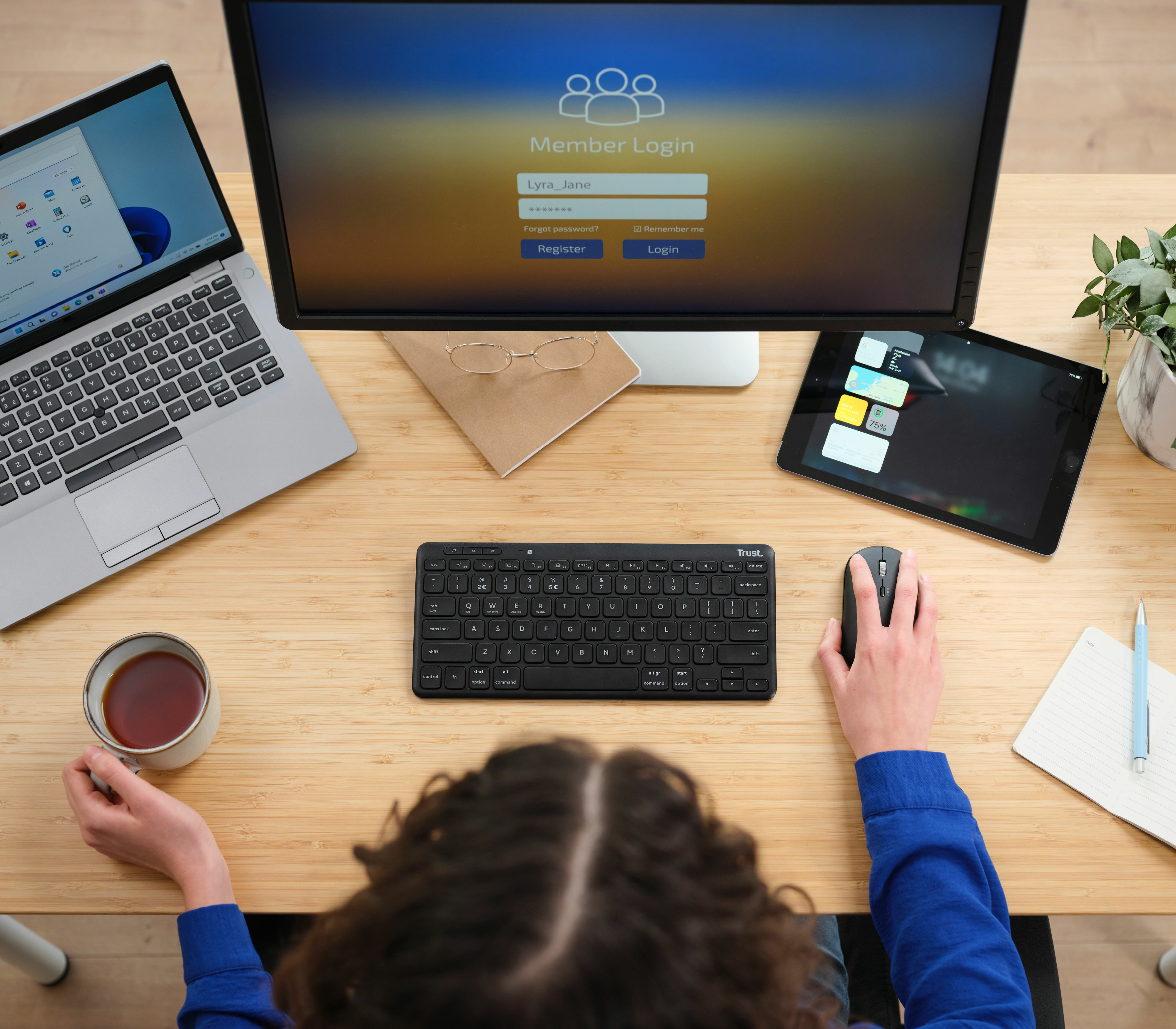 Widok z góry na konfigurację biurka z klawiaturą, myszą, monitorem i tabletem.