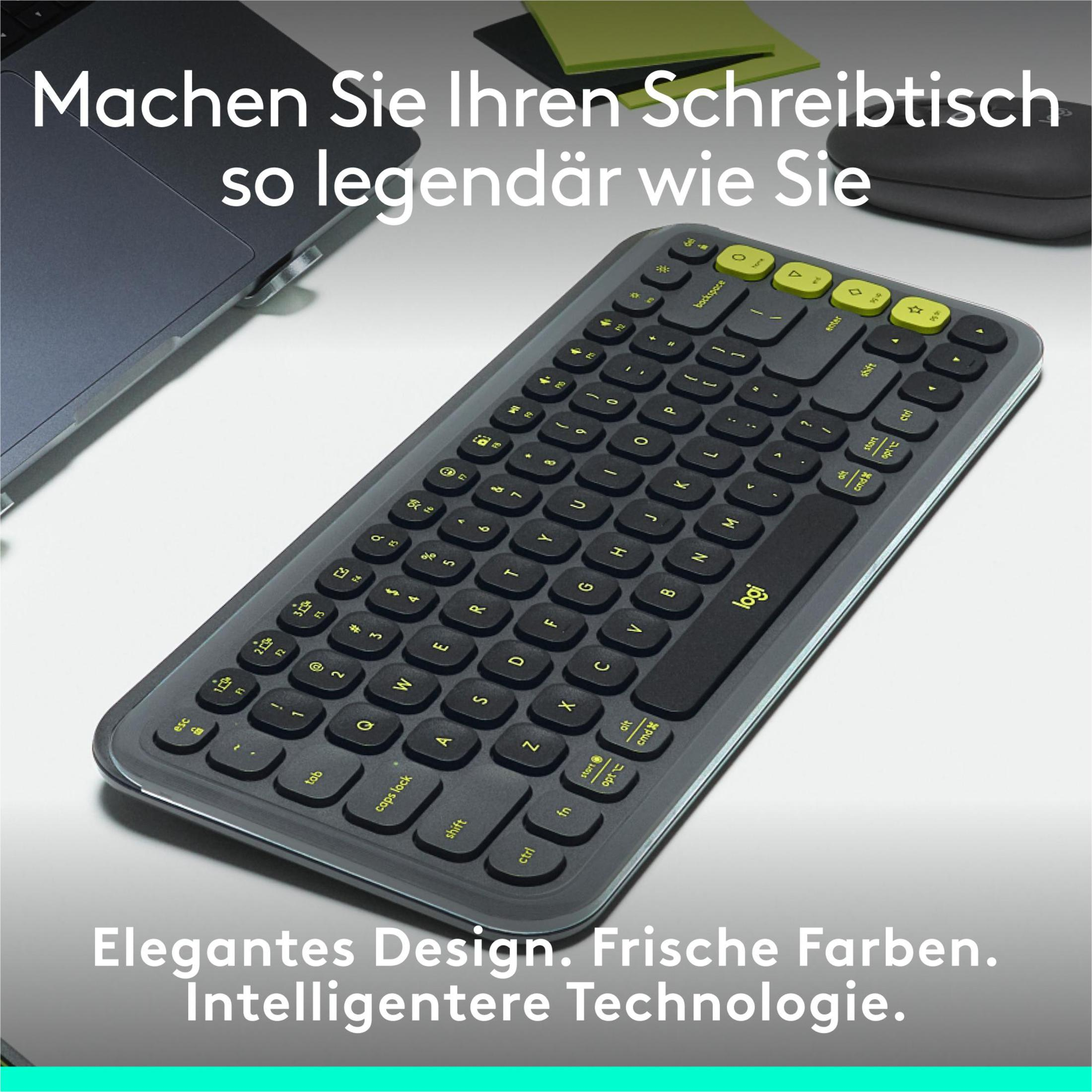 Szara klawiatura z żółtymi akcentami, laptop i zielona karteczka na białej powierzchni.