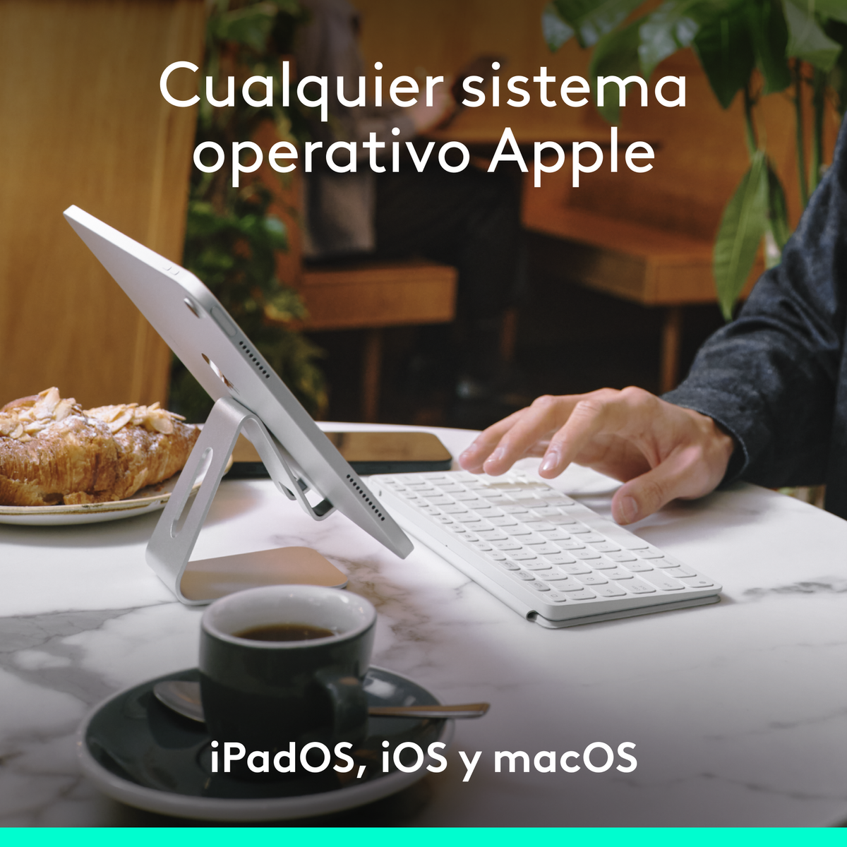 Tablet su supporto con tastiera, caffè e pasticceria, testo: Sistema operativo Apple.