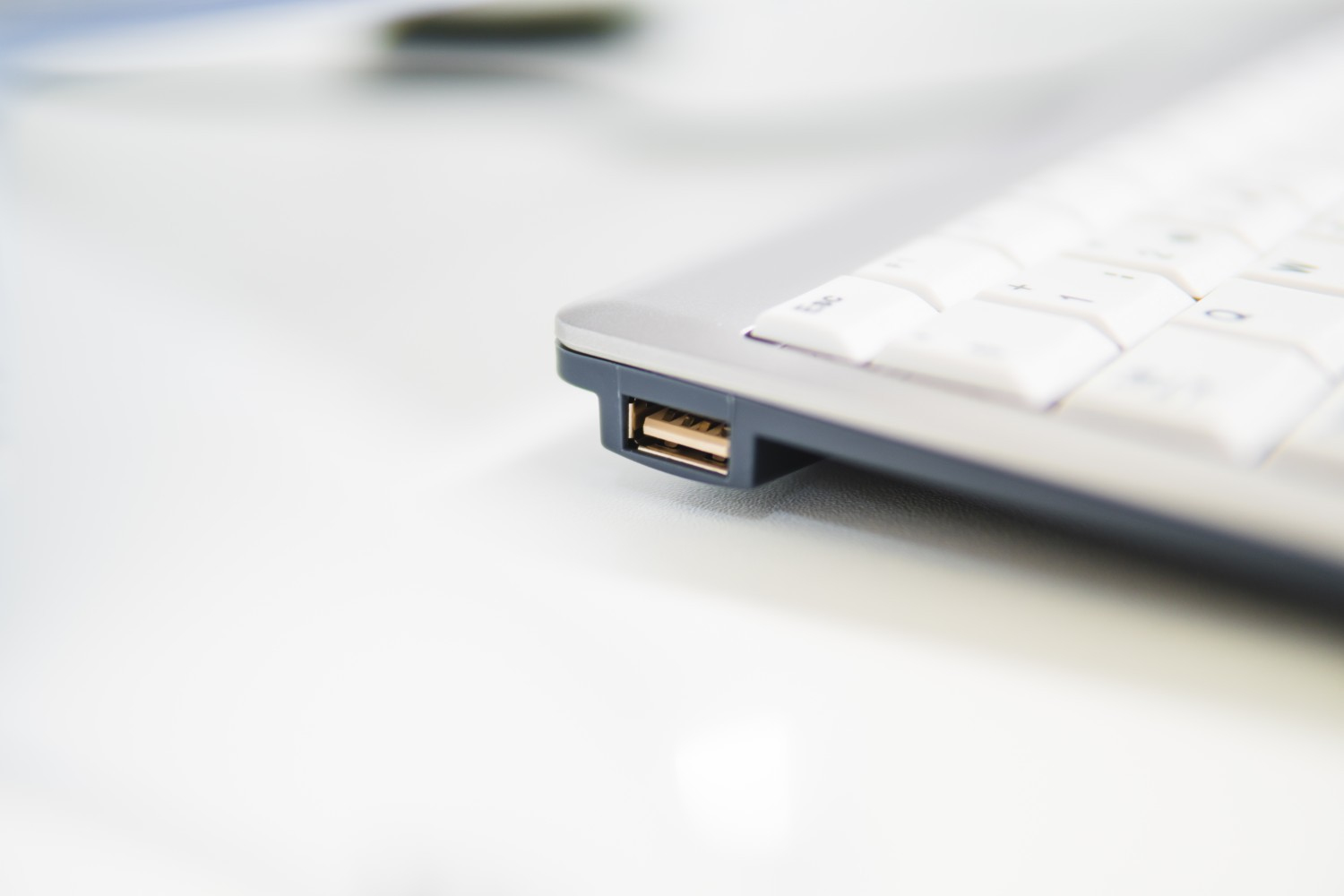 Primo piano di una tastiera argentata con una porta USB sul lato.