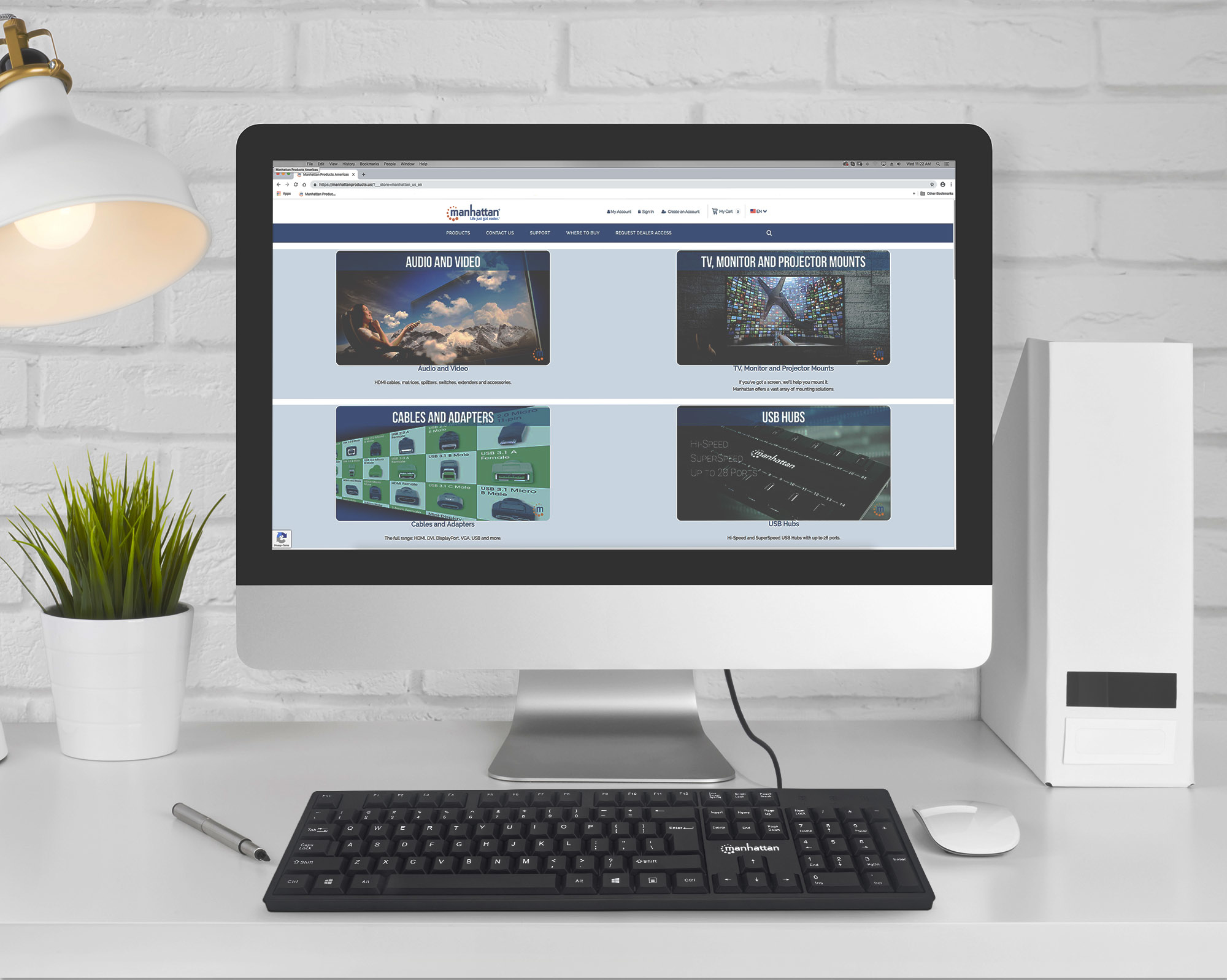 Konfiguracja komputera z monitorem pokazującym stronę internetową. Klawiatura i mysz na biurku.