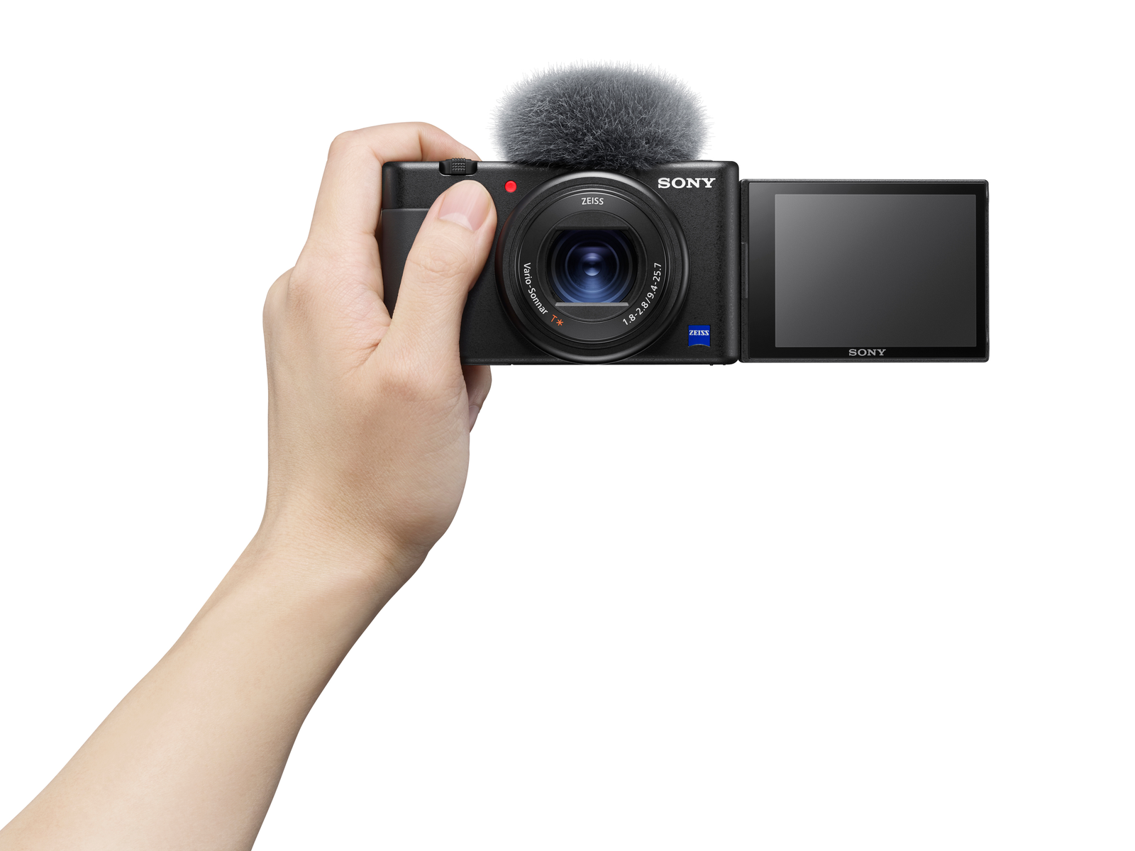 Hand die een zwarte Sony camera vasthoudt met aangesloten microfoon en open scherm met een video-opname.