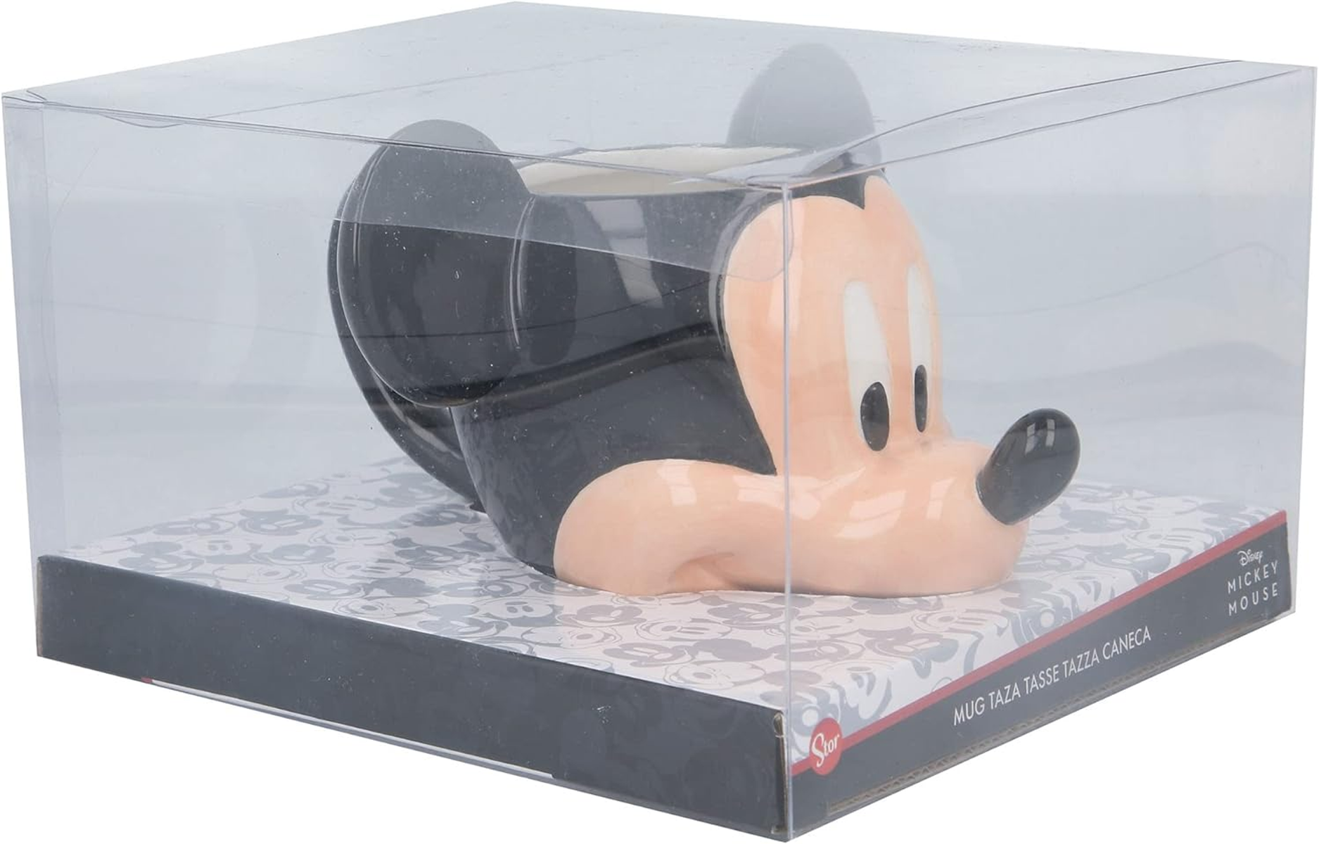 Taza de Mickey Mouse en una caja de plástico transparente, sobre un fondo estampado.