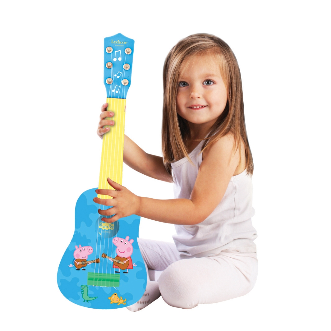 Dziewczynka trzyma gitarę Peppy. Niebieska gitara z postaciami Peppy. Białe tło.