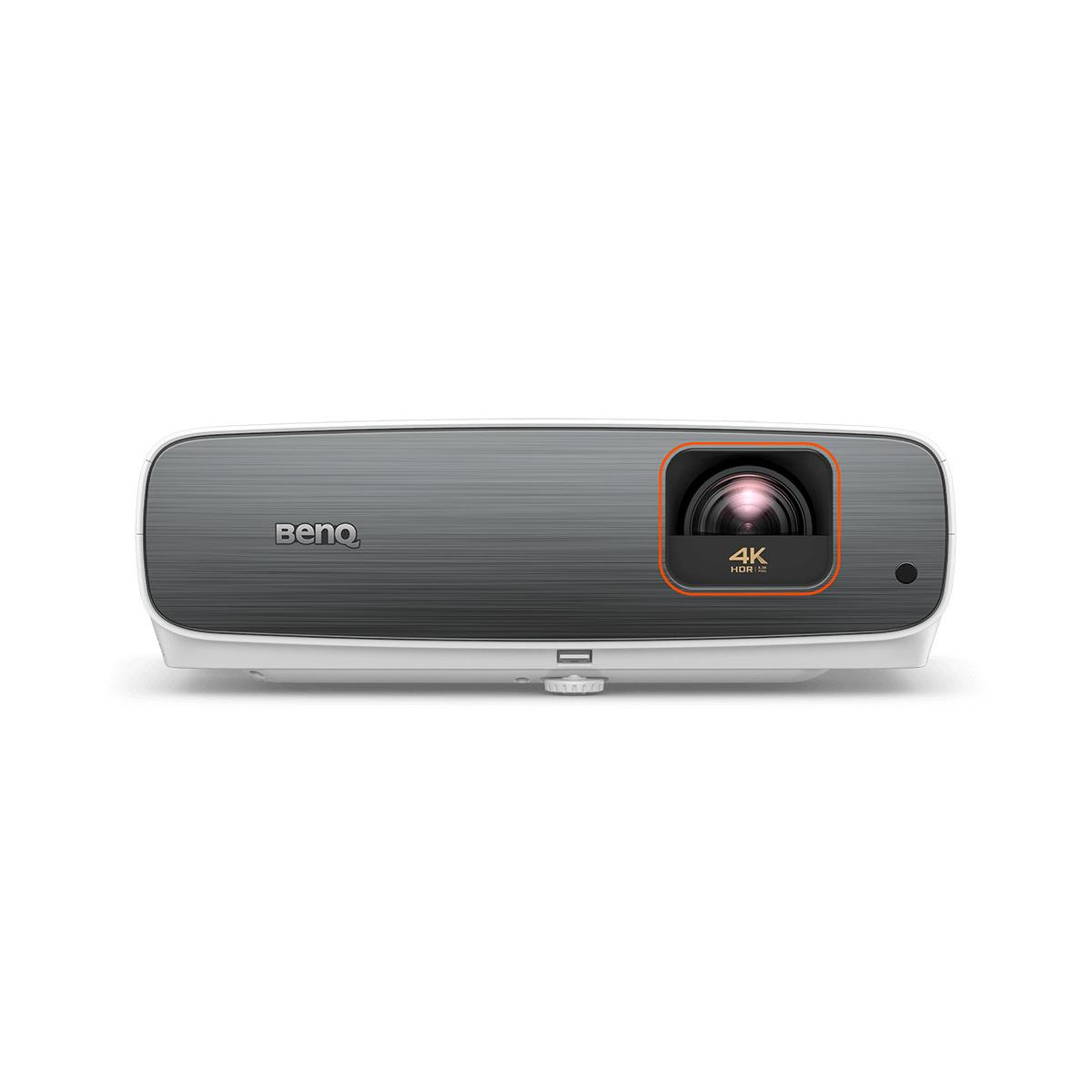 Un proyector BenQ, blanco y gris con una lente naranja. Está sobre un fondo blanco.