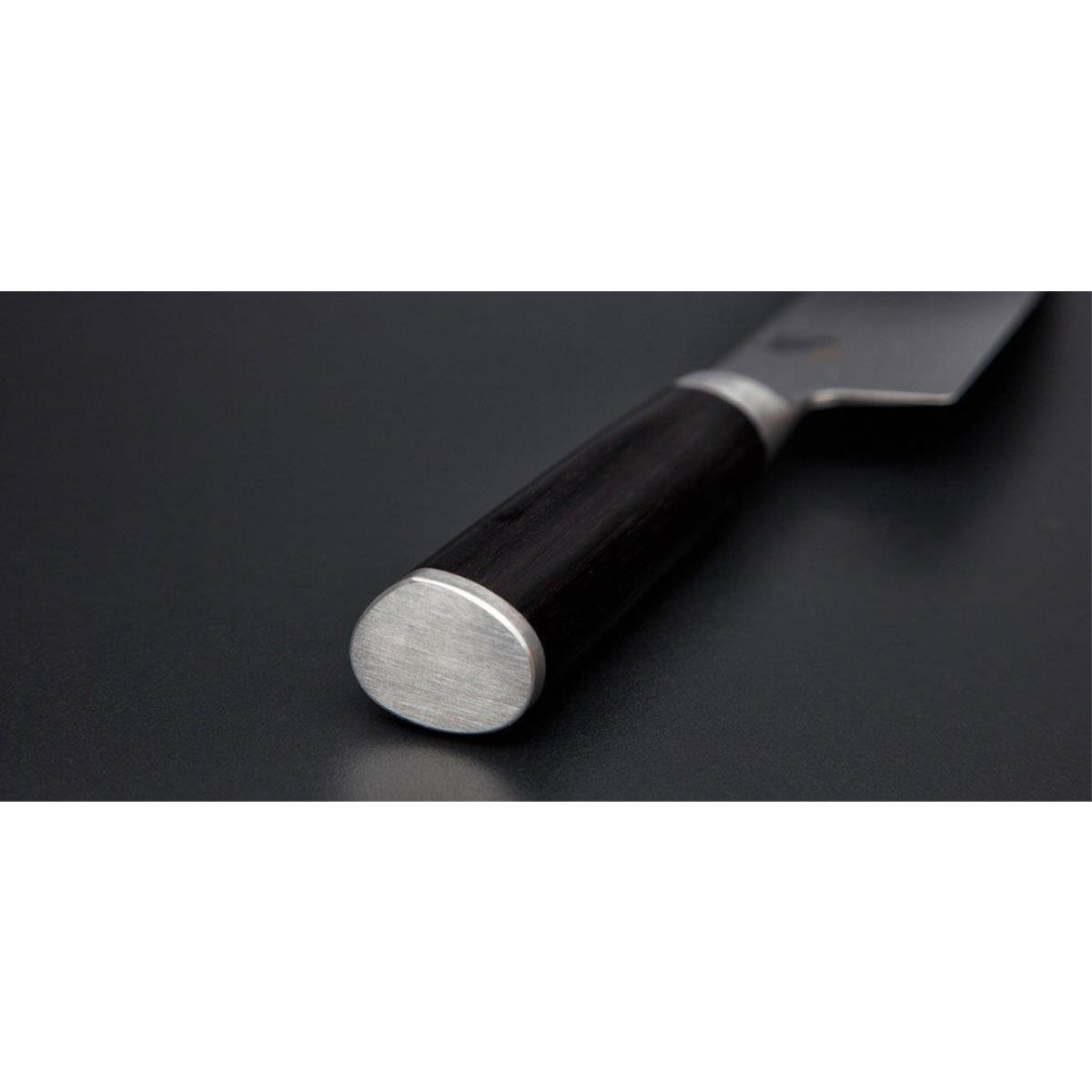 Zbliżenie rękojeści i ostrza noża. Rękojeść jest ciemna, metal srebrny.