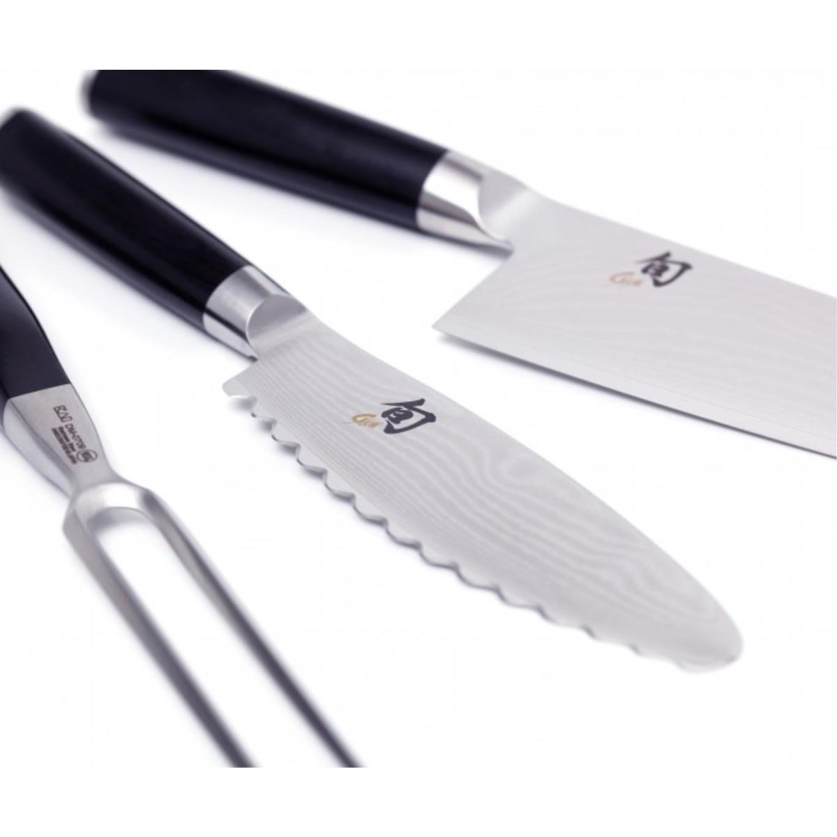 Trzy noże i widelec leżą na białej powierzchni; noże mają czarne uchwyty i srebrne ostrza.