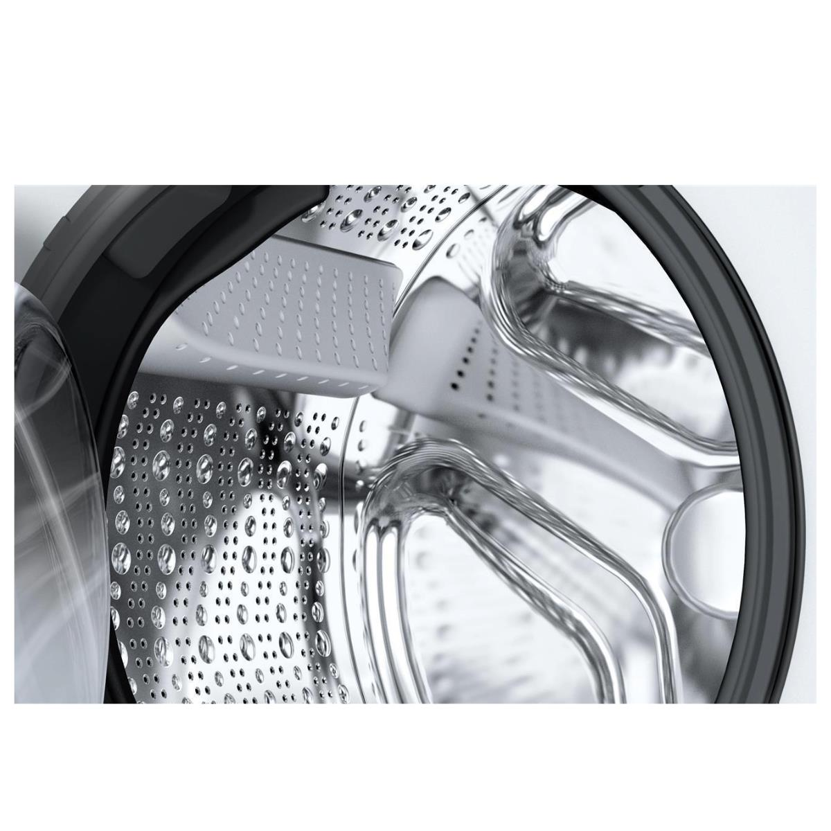 Zbliżenie bębna pralki. Widoczne są otwory i krople wody.