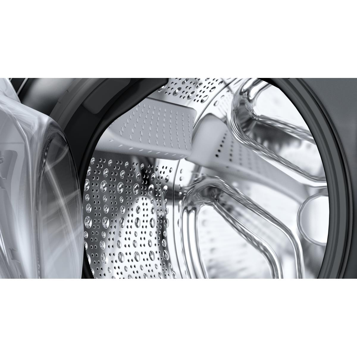 Close-up van de trommel van de wasmachine met waterdruppels. Chroom interieur, transparante deur.