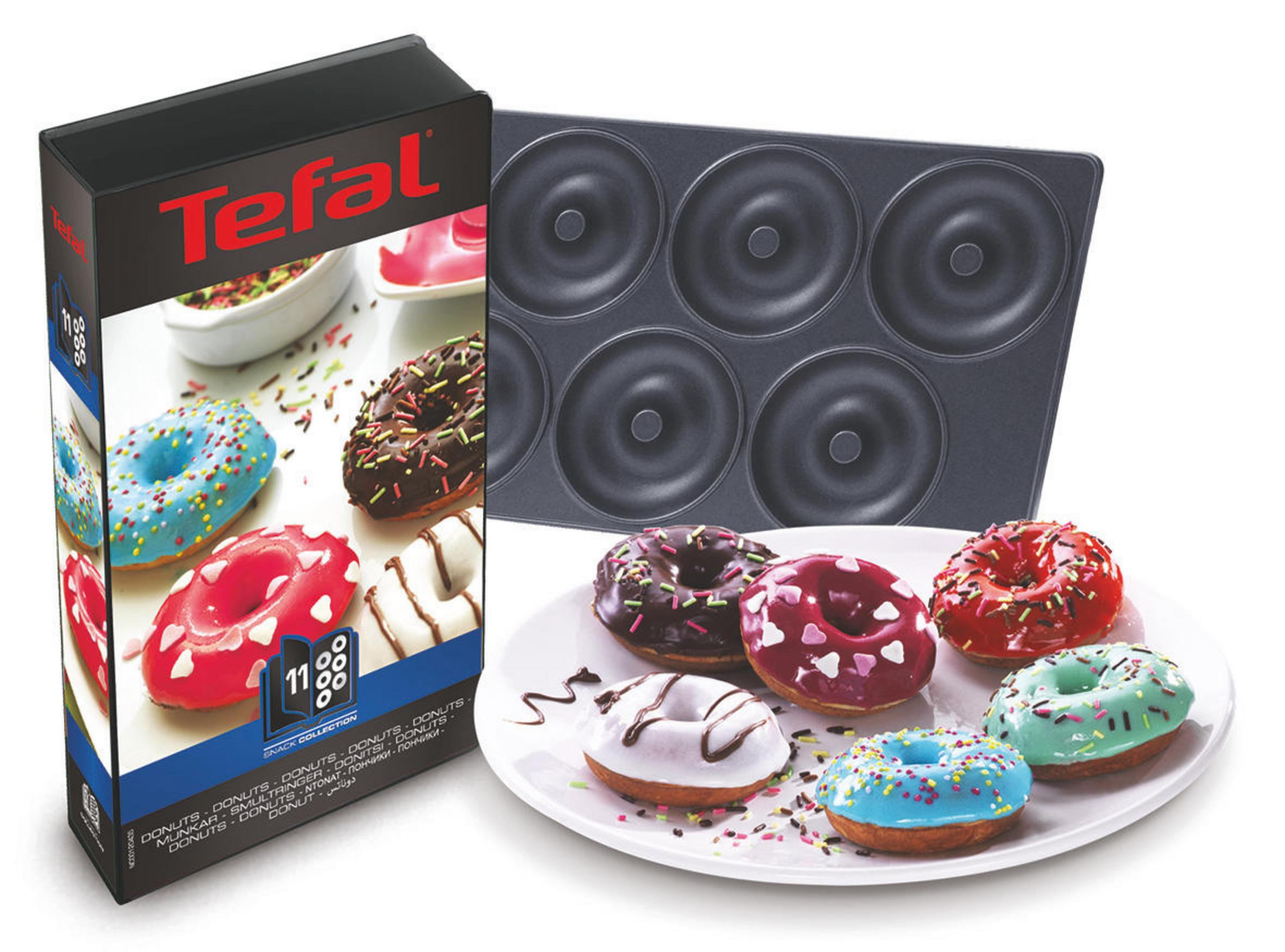 Une boîte de donuts Tefal et une plaque à donuts. Les donuts sont sur une assiette. La boîte est colorée.