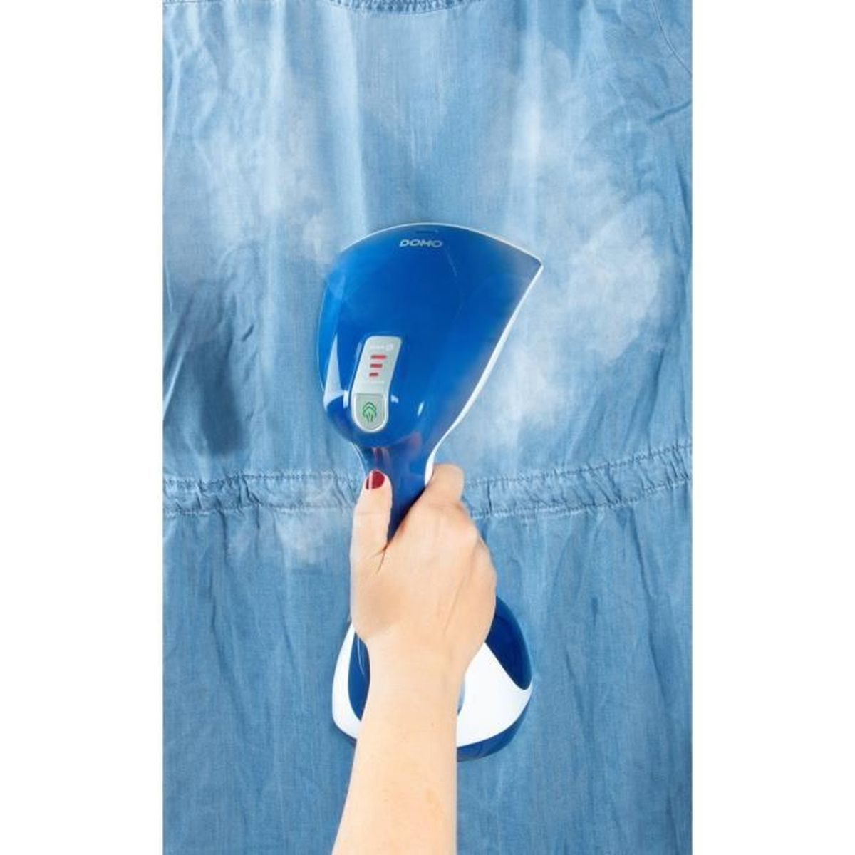 Eine Hand hält einen blauen Dampfer über einem blauen Jeanshemd, wobei Dampf aus dem Kleidungsstück aufsteigt.