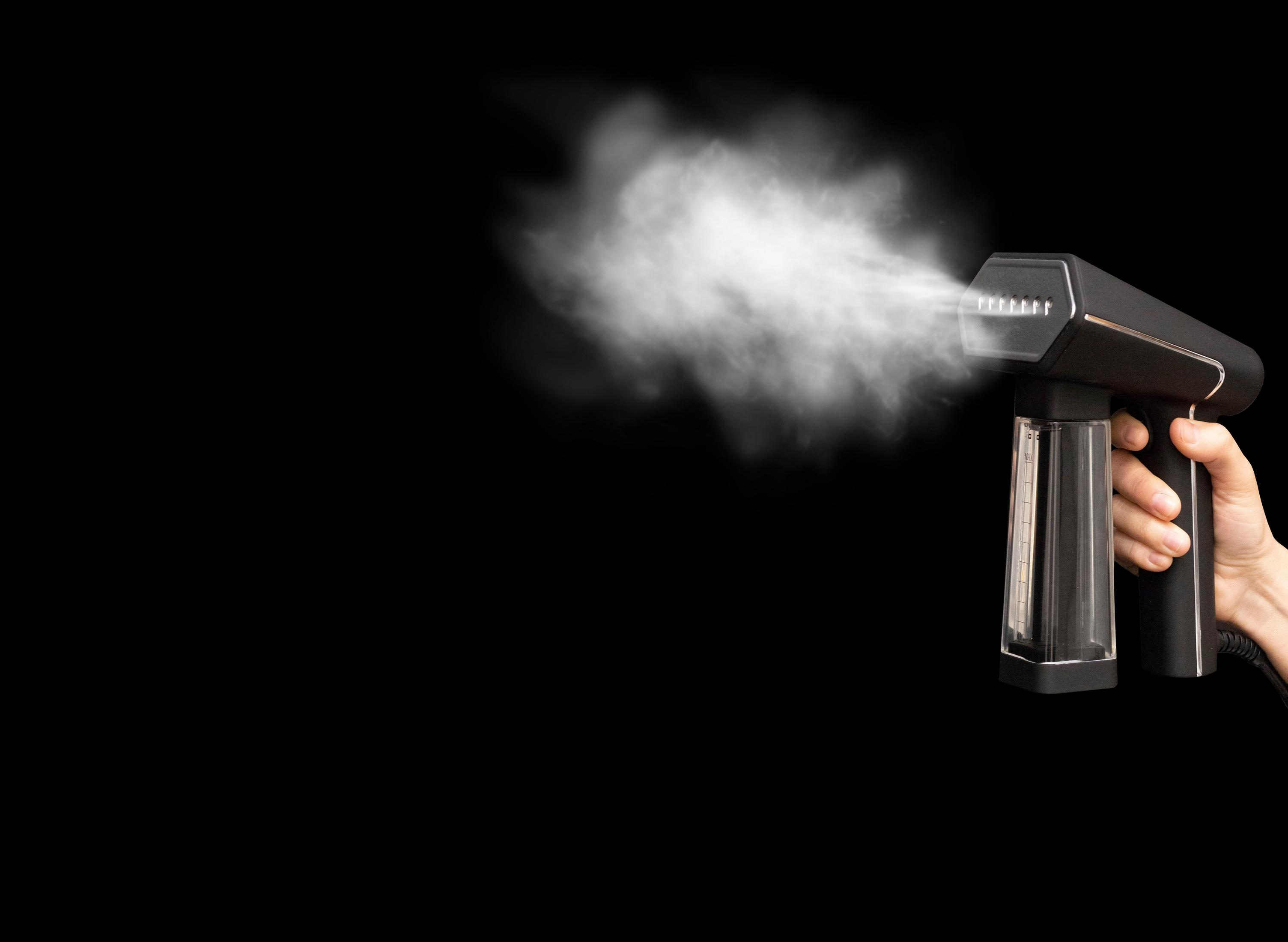 Mano che tiene vaporizzatore nero con vapore. Sfondo nero.