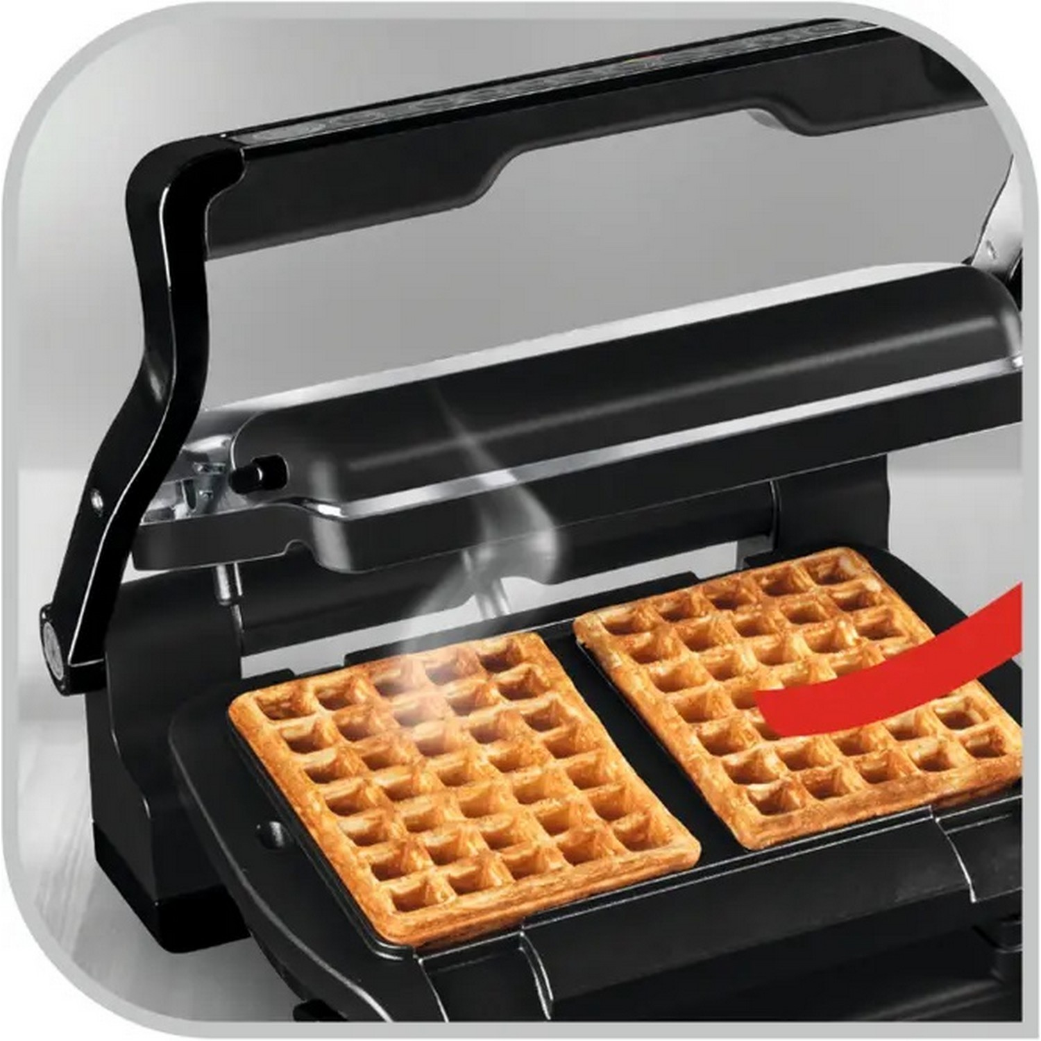 Schwarzer Waffelautomat, offen, mit Waffeln, Dampf aufsteigend, mit rotem Pfeil.