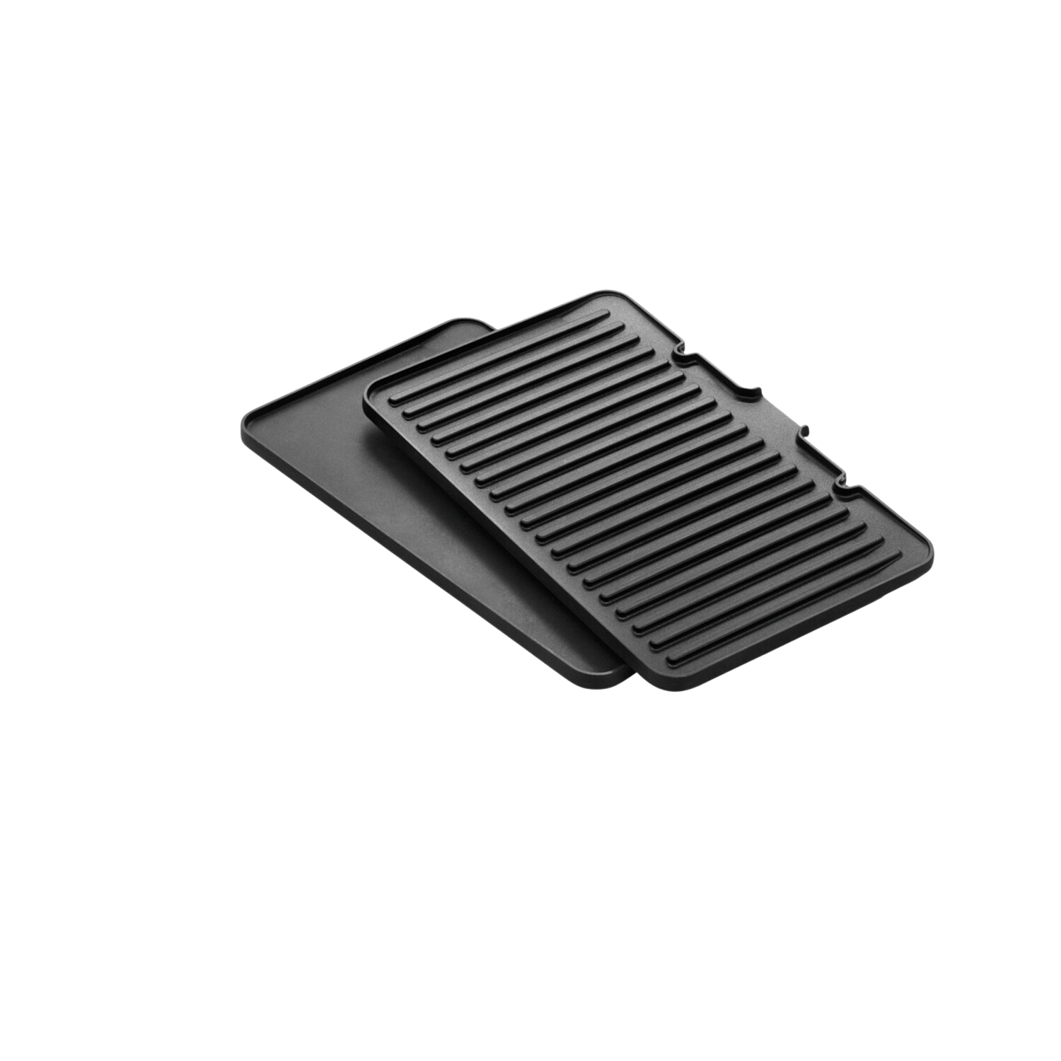 Zwarte grillpan en bakplaat op een zwart oppervlak. De bakplaat ligt erbovenop.