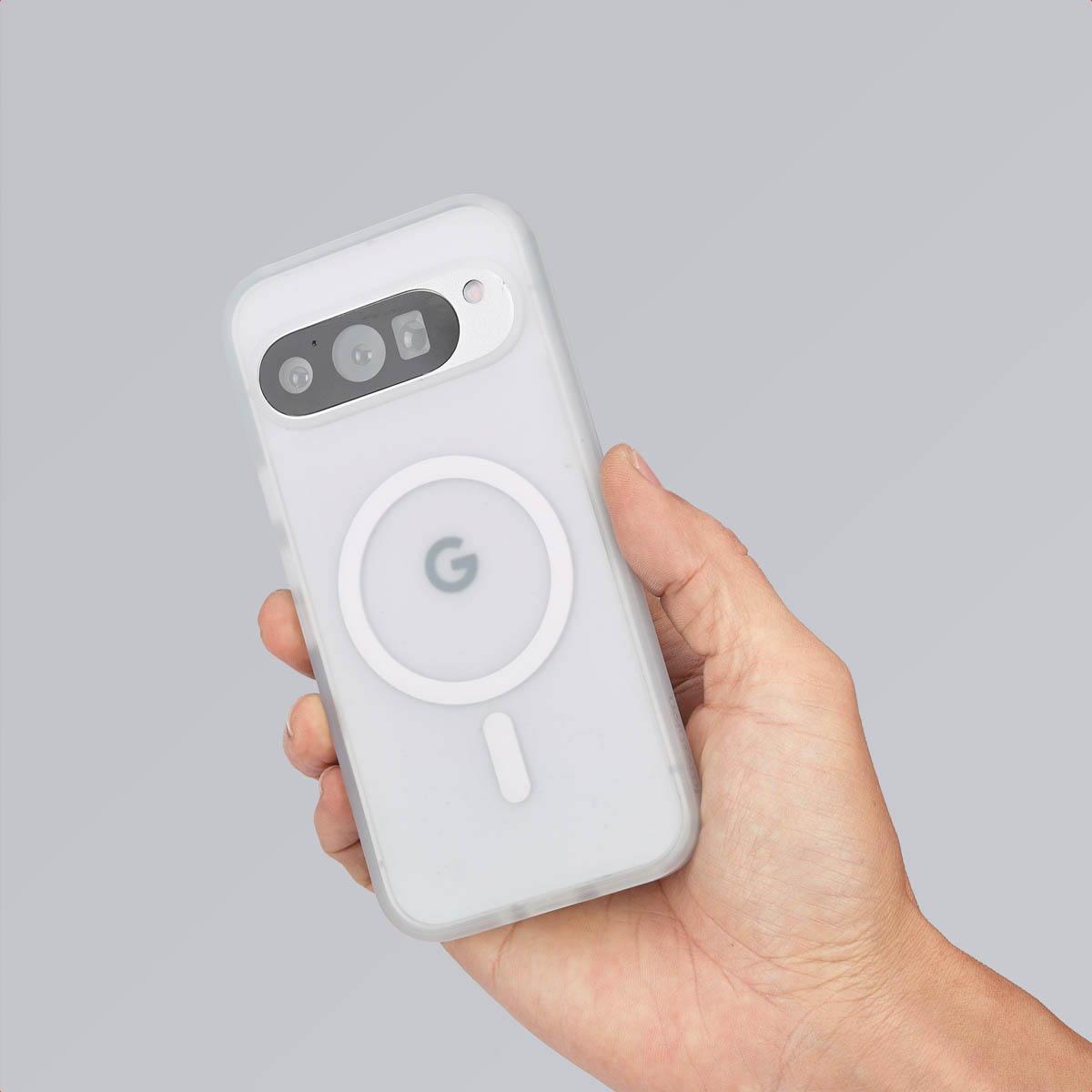 Hand die een witte telefoon met een hoesje vasthoudt. Het hoesje heeft een cirkel en de letter 'G'.