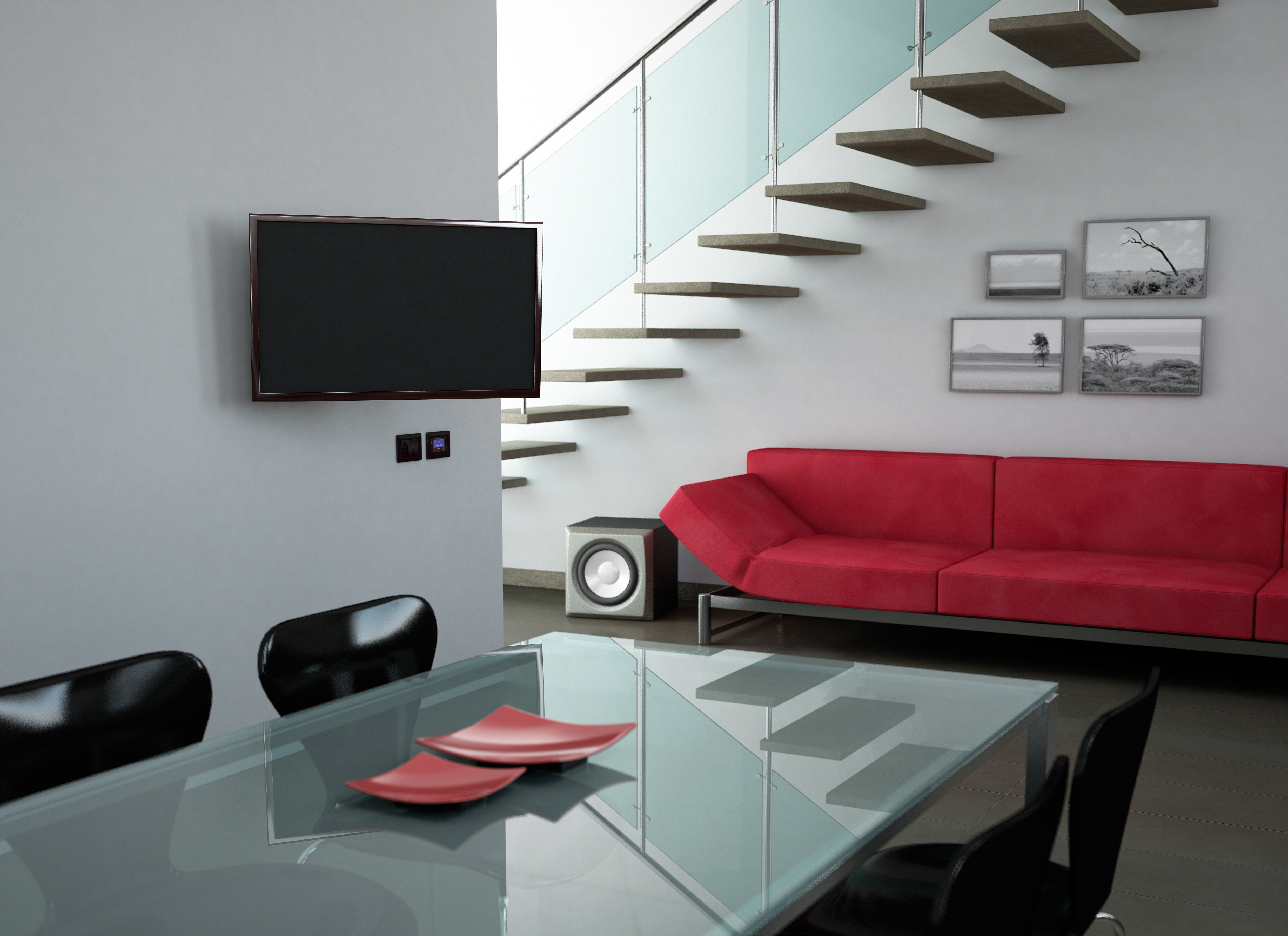 Ein Fernseher ist an einer weißen Wand montiert. Ein rotes Sofa und ein Glastisch.