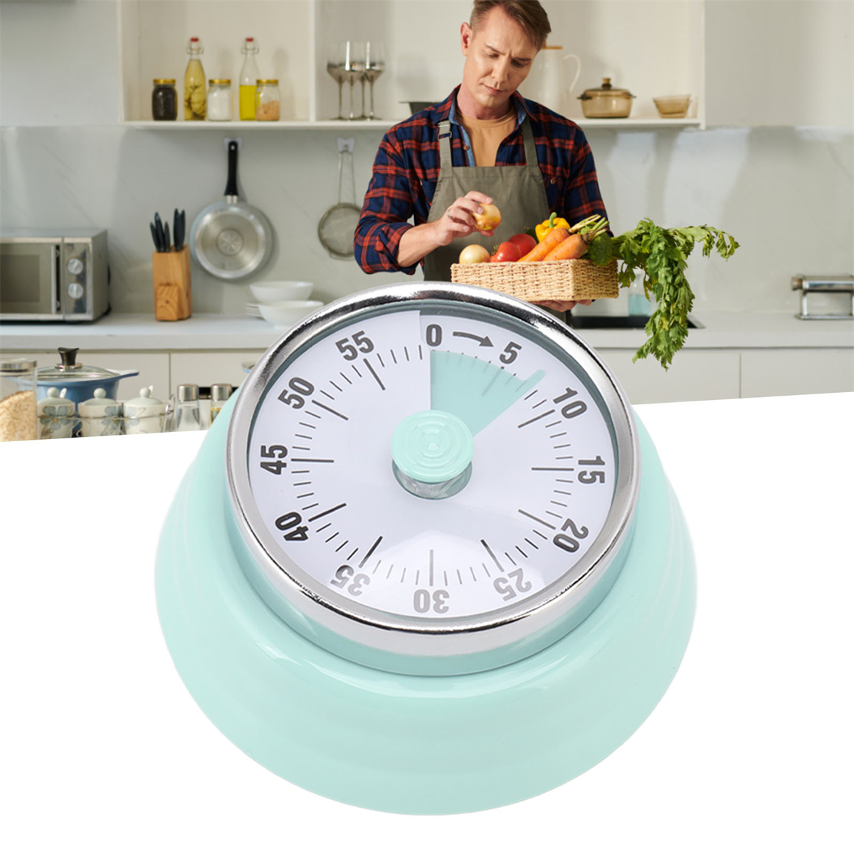 Ein mintgrüner Küchentimer, eingestellt auf 5 Minuten. Ein Mann ist im Hintergrund sichtbar.