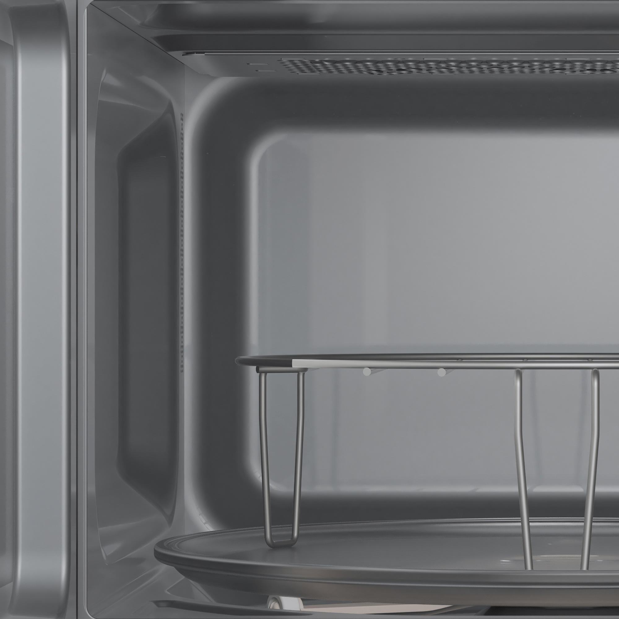 Wnętrze szarej kuchenki mikrofalowej. Jest metalowa taca i szklany talerz.