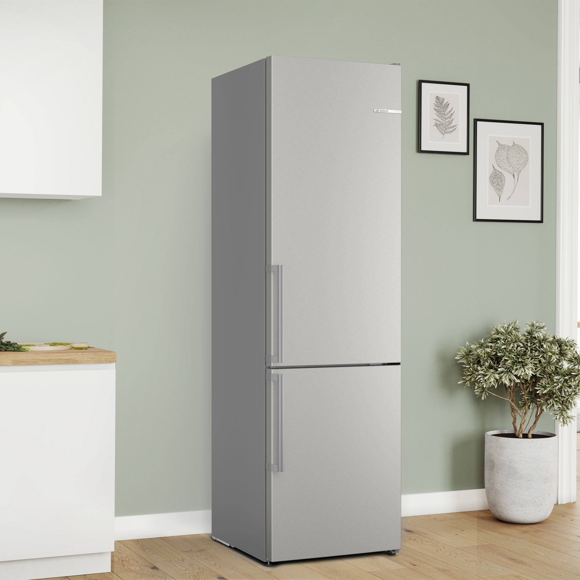 Silberner Kühlschrank mit zwei Türen steht in einem Raum mit grüner Wand.