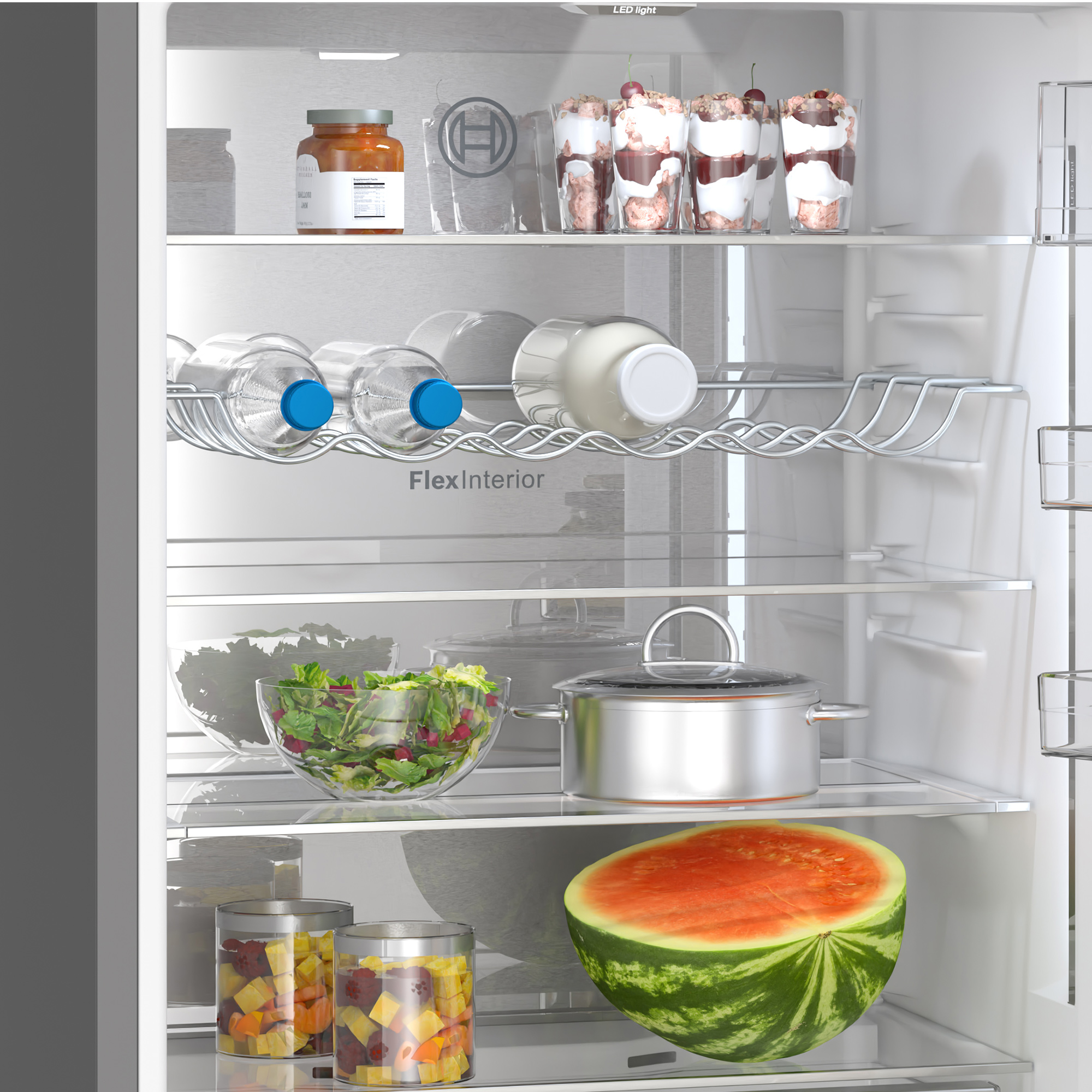 Wnętrze lodówki z jedzeniem. Słoiki, miski z sałatką, butelki wody, owoce.