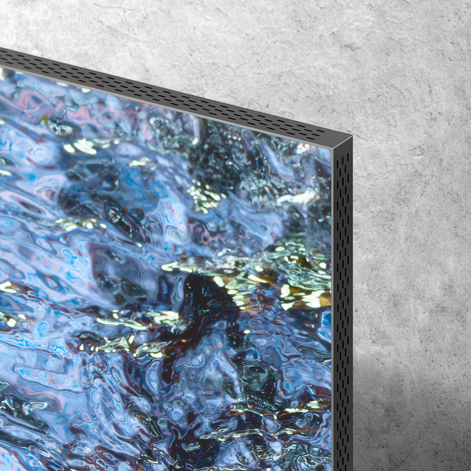 Close up of a TV screen with a blue water scene, next to a grey wall.