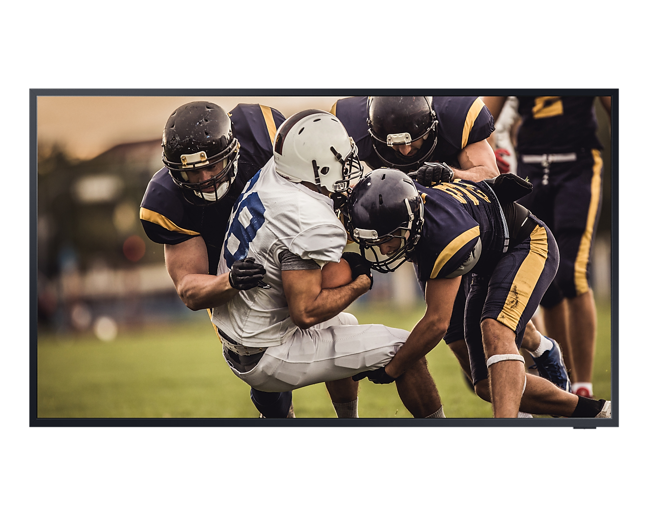Ekran telewizora pokazujący mecz futbolu amerykańskiego, z zawodnikami w akcji. Telewizor jest czarny.
