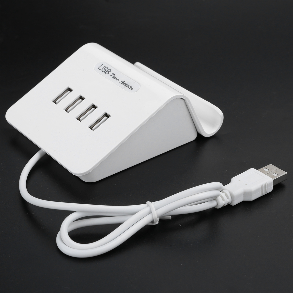 Weißer USB-Netzadapter mit vier Anschlüssen und angeschlossenem USB-Kabel.
