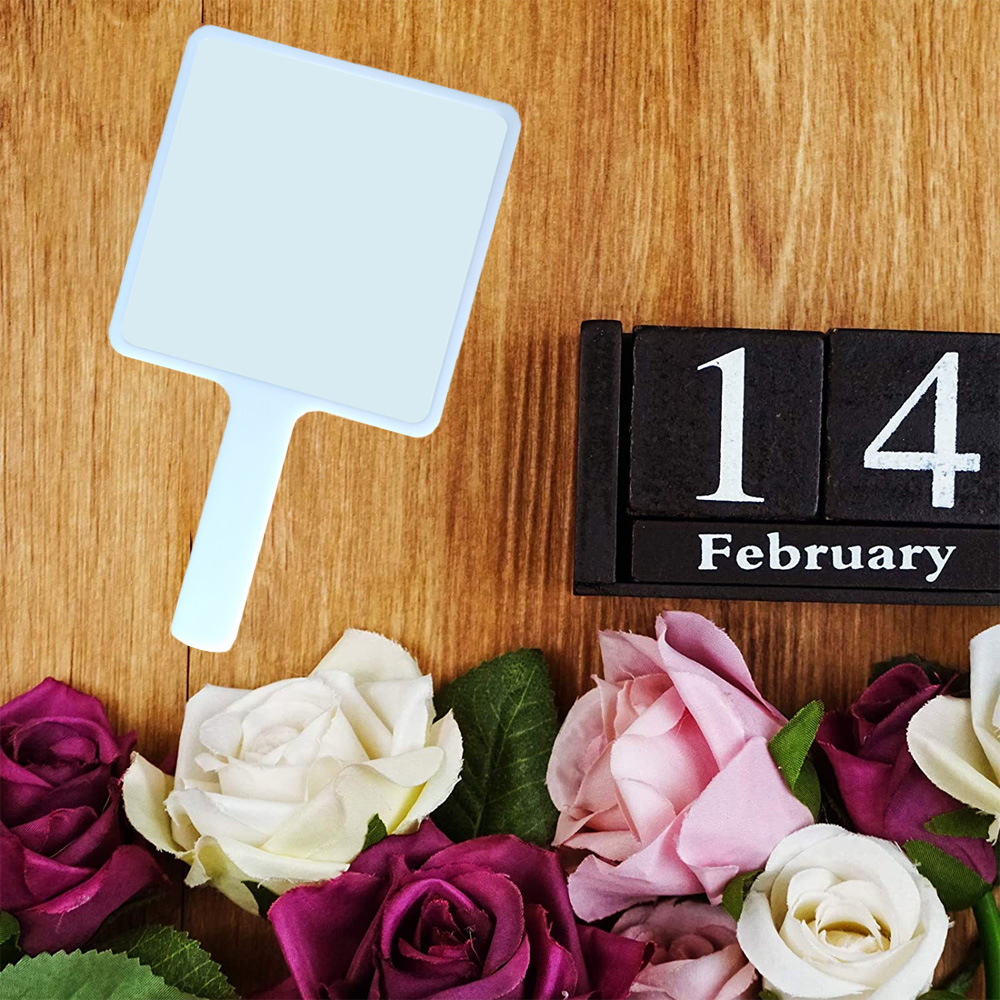Valentinstag-Arrangement mit Rosen und einem Kalender, der den 14. Februar zeigt, auf einer Holzoberfläche.