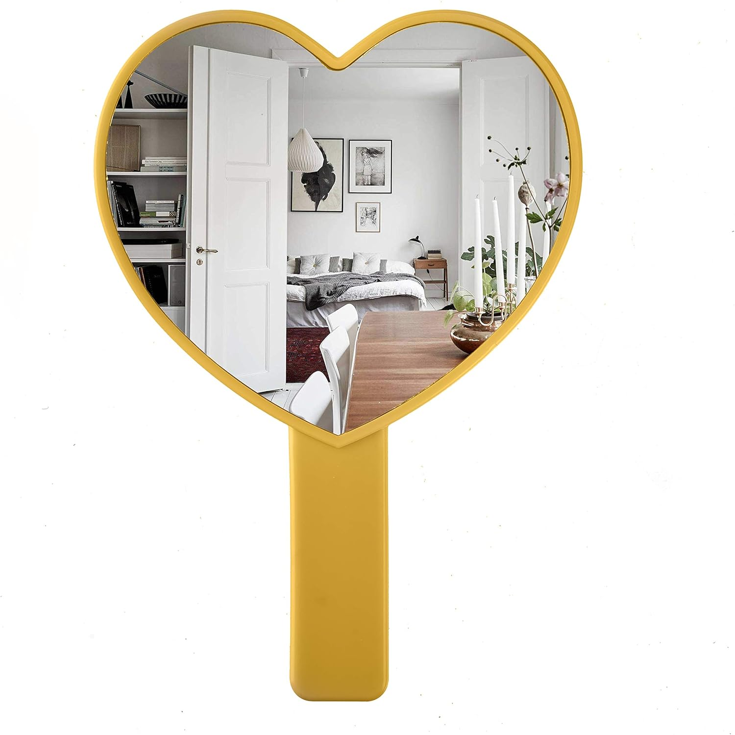 Gelber herzförmiger Spiegel, der ein Zimmer mit Bett, Tisch und Kerzen reflektiert. Weißer Hintergrund.