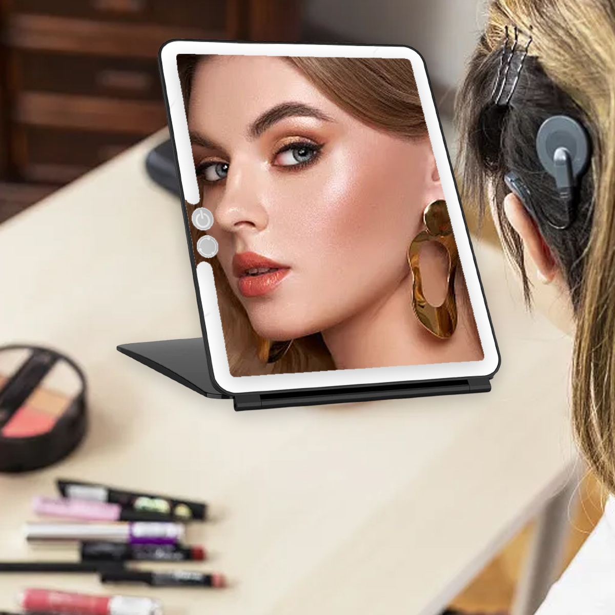 Eine Frau blickt in einen beleuchteten Schminkspiegel, mit Make-up-Artikeln auf einem hellen Tisch.