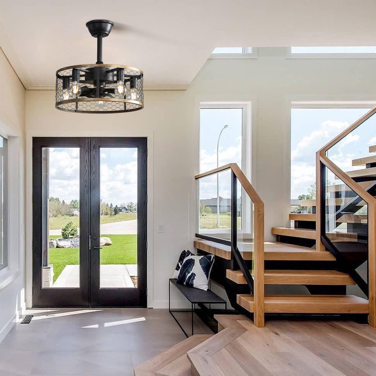 Ein Flur mit Deckenventilator, Treppe und Glastür und einer schwarzen Haustür.