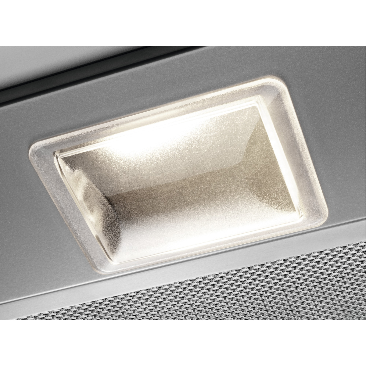 Primo piano di un apparecchio di illuminazione incassato rettangolare illuminato in un soffitto in acciaio inossidabile.