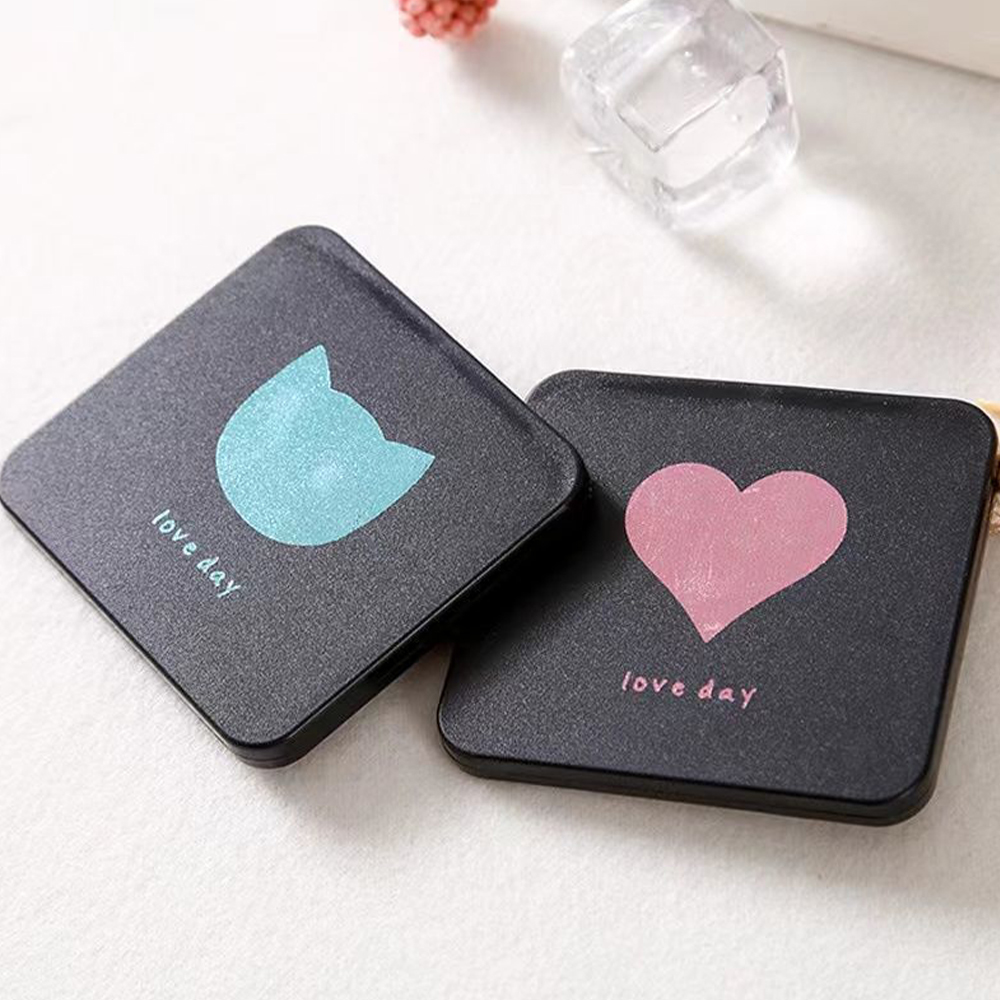 Zwei schwarze, quadratische Kompaktspiegel mit Katzen- und Herzdesign, mit dem Schriftzug 'love day'.