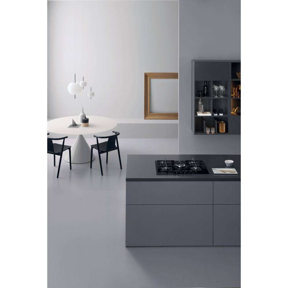 Un'immagine interna di una cucina moderna. Un'isola cucina grigio scuro con un piano cottura a gas e un lampadario.