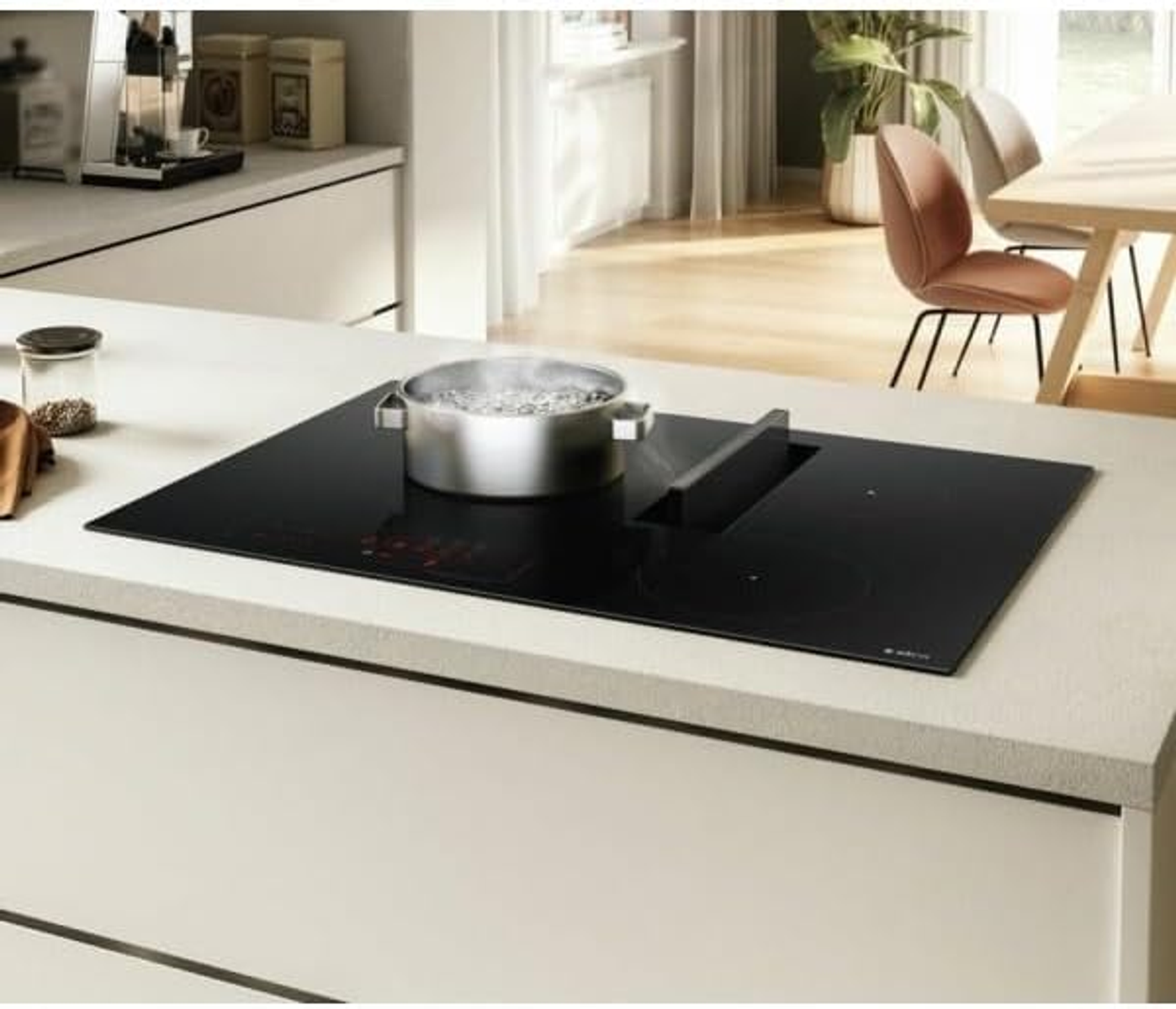 Czarna płyta indukcyjna z garnkiem i wbudowanym okapem, w kuchni.