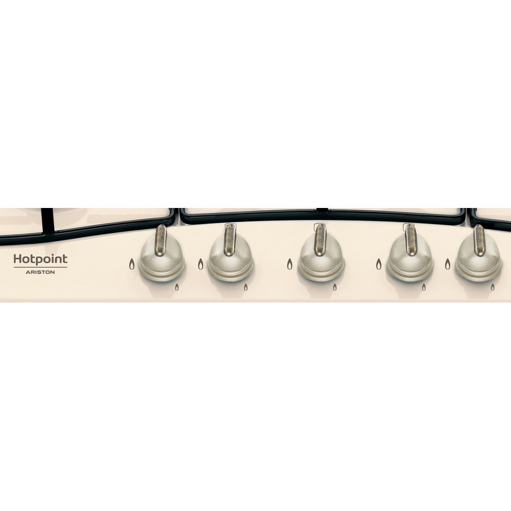 Zbliżenie na pokrętła kremowej kuchenki gazowej. Marka to Hotpoint Ariston.