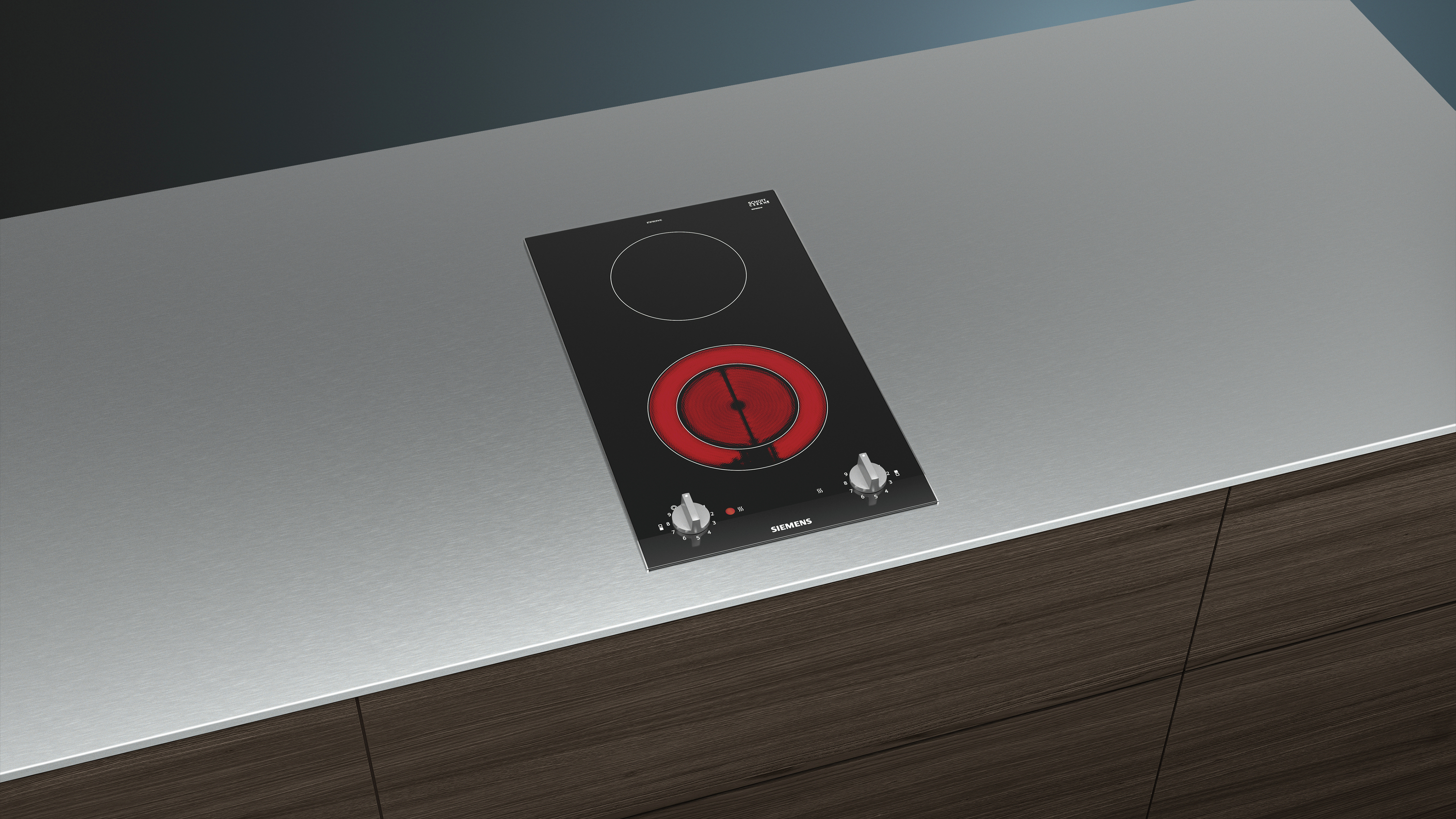 Czarna płyta indukcyjna z dwoma palnikami na srebrnym blacie.