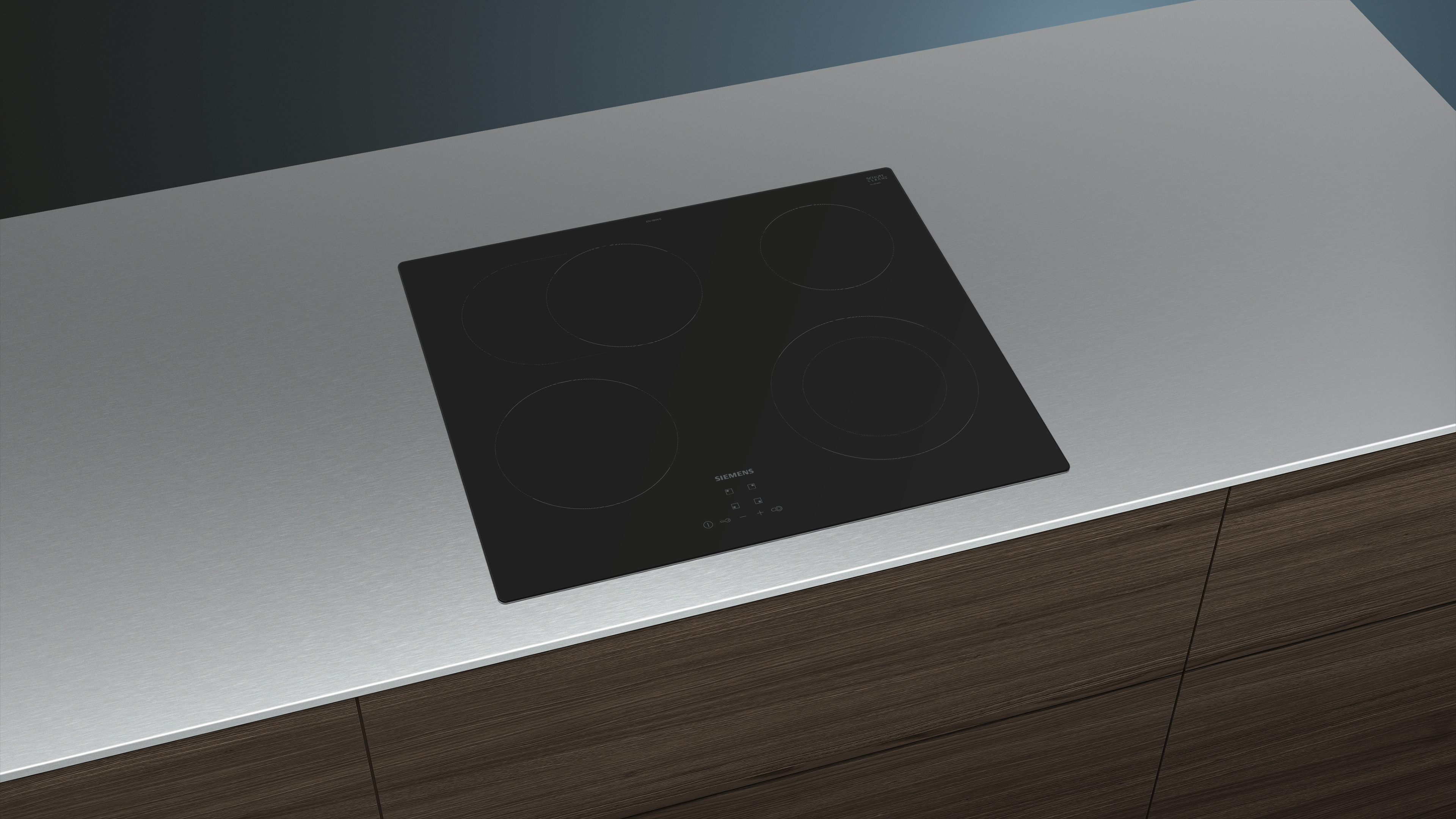 Black induction cooktop on a countertop, four circular cooking zones, modern design.
