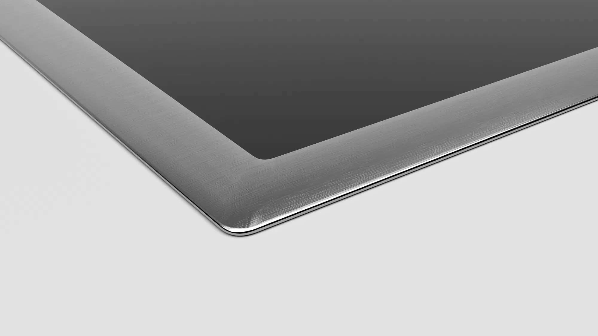 Een hoek van een tablet met een zwart scherm en een zilverkleurige metalen rand.