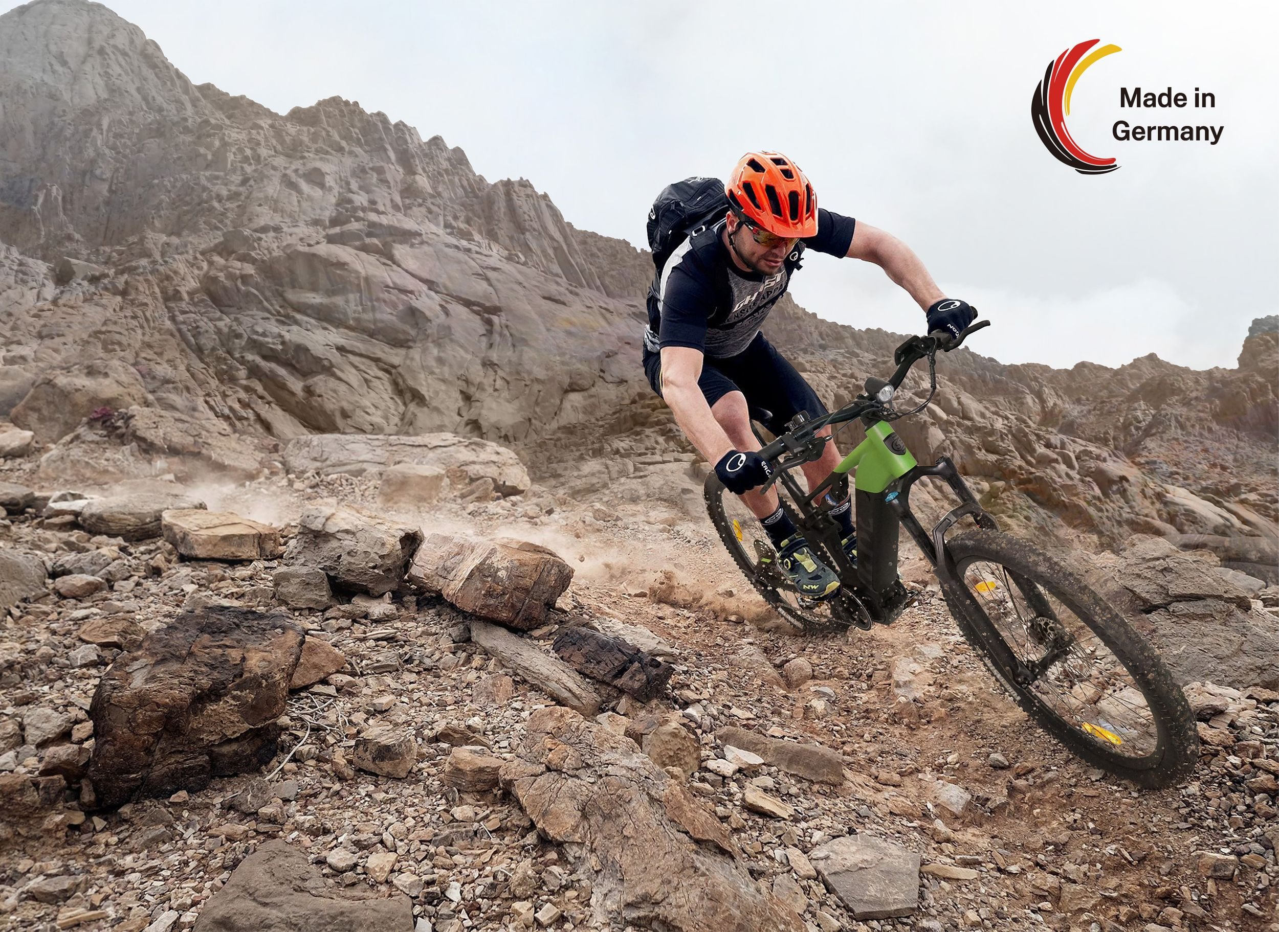 Ein Mann auf einem Mountainbike fährt einen felsigen Pfad hinunter, mit einem Berg im Hintergrund.