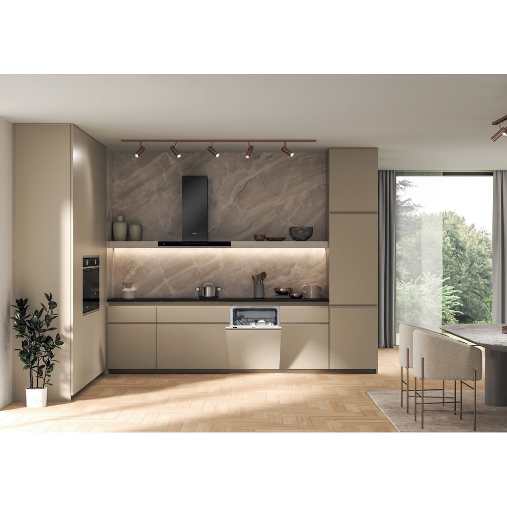Interni cucina moderna con mobili beige, una cappa nera e una lavastoviglie. Pavimento in legno.