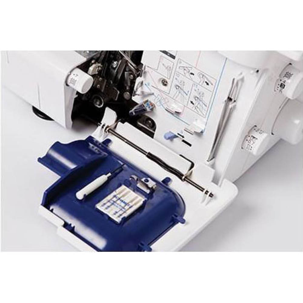 Naaimachine-interieur met open vak. Blauw dienblad met accessoires, naalden en een witte pen.