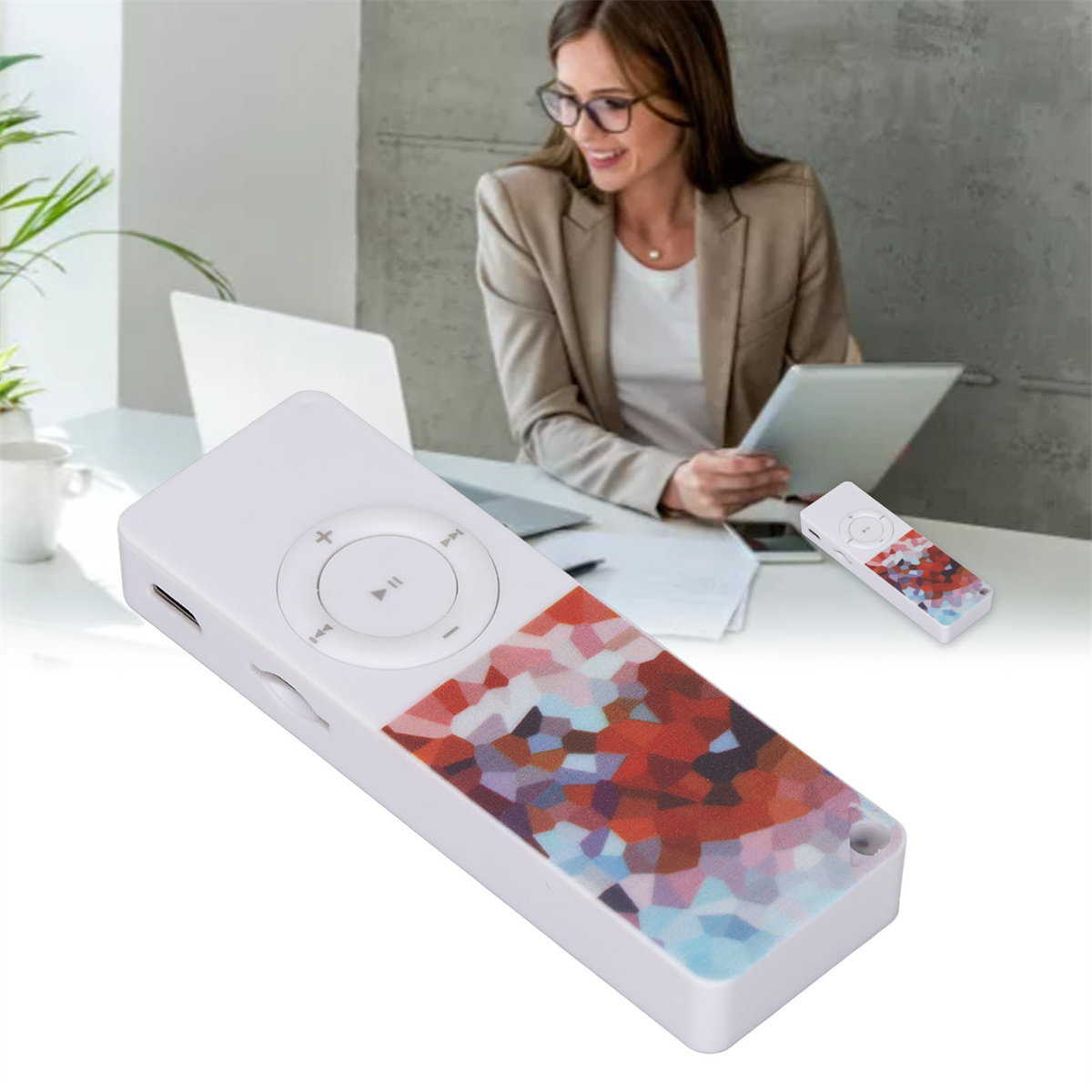 Eine Frau in einem Blazer sitzt an einem Schreibtisch mit einem Laptop und hält ein Tablet. Ein kleiner Musikplayer wird gezeigt.