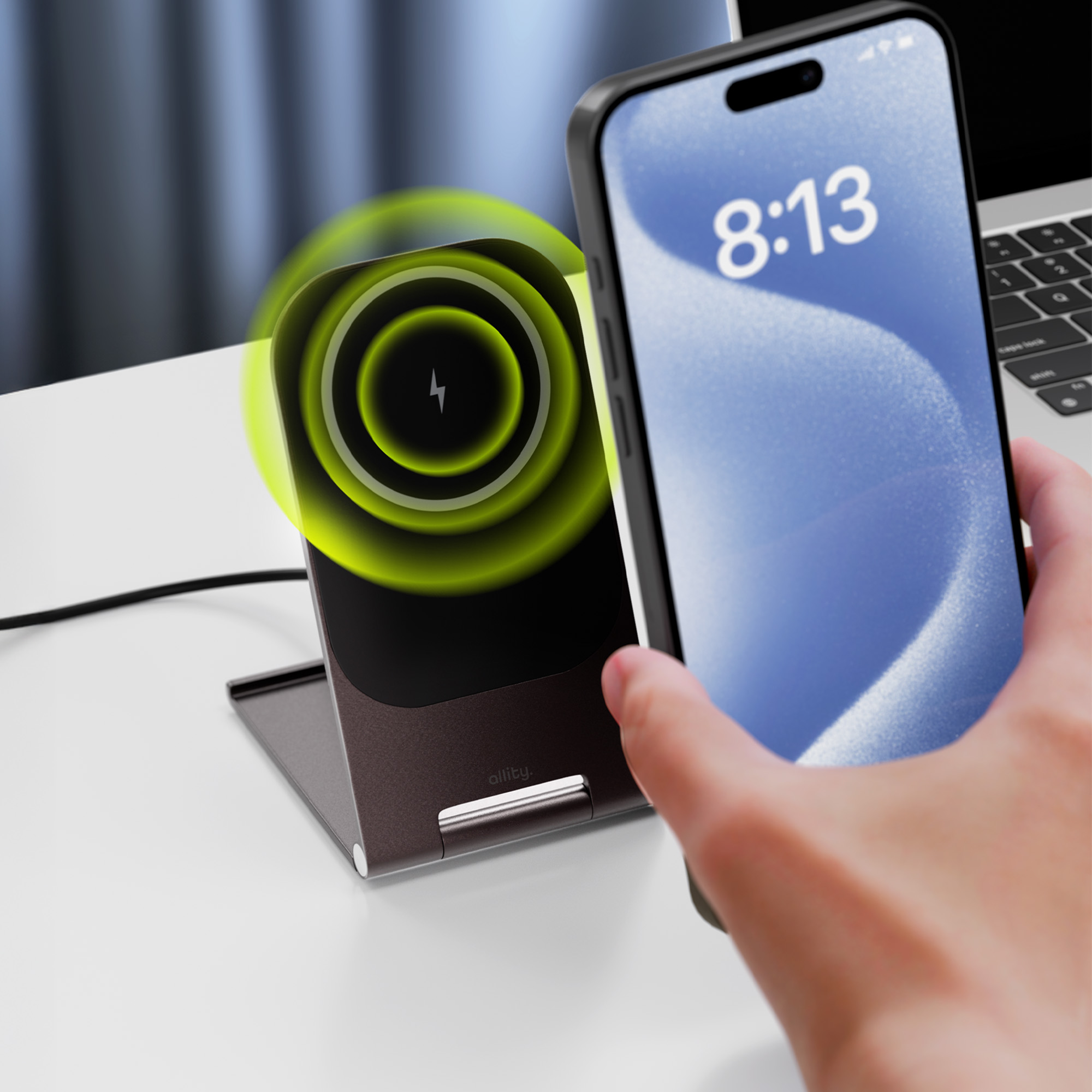 Telefon na brązowej ładowarce bezprzewodowej, ładujący się. Dłoń trzyma telefon z wyświetloną godziną.