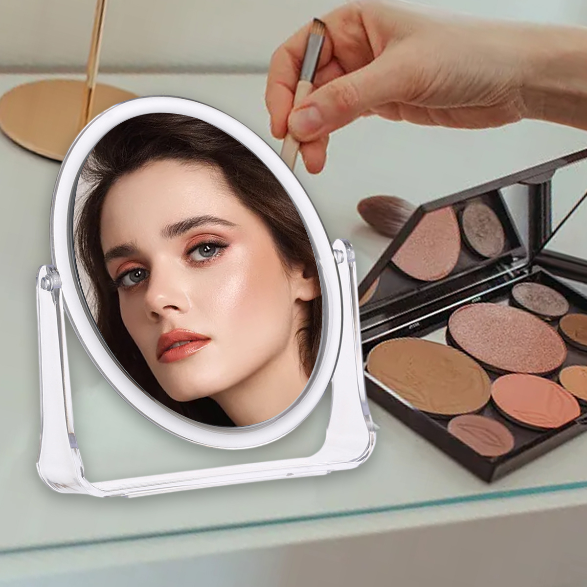 Ovaler Spiegel mit Frauenreflexion und Make-up-Palette auf weißer Oberfläche, mit Pinsel.