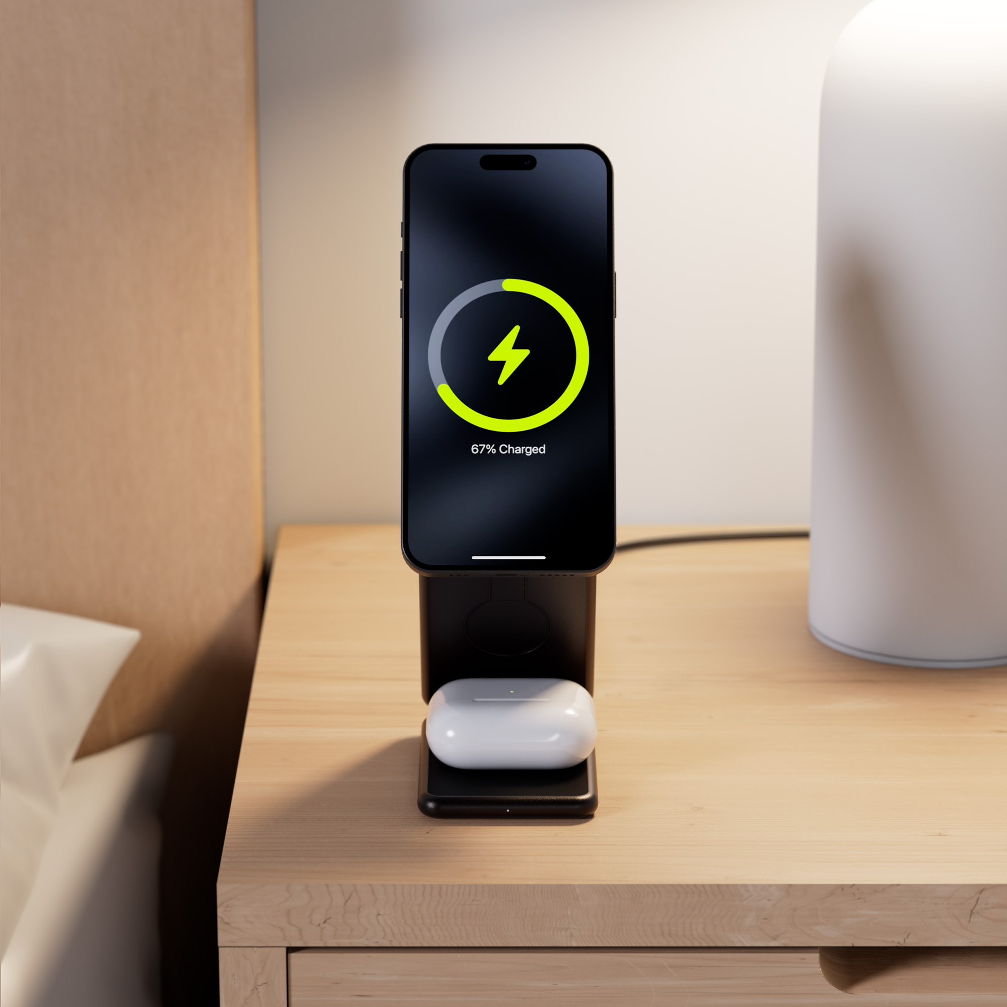 Stacja ładowania bezprzewodowego z telefonem i słuchawkami. Telefon się ładuje, 67% naładowany.